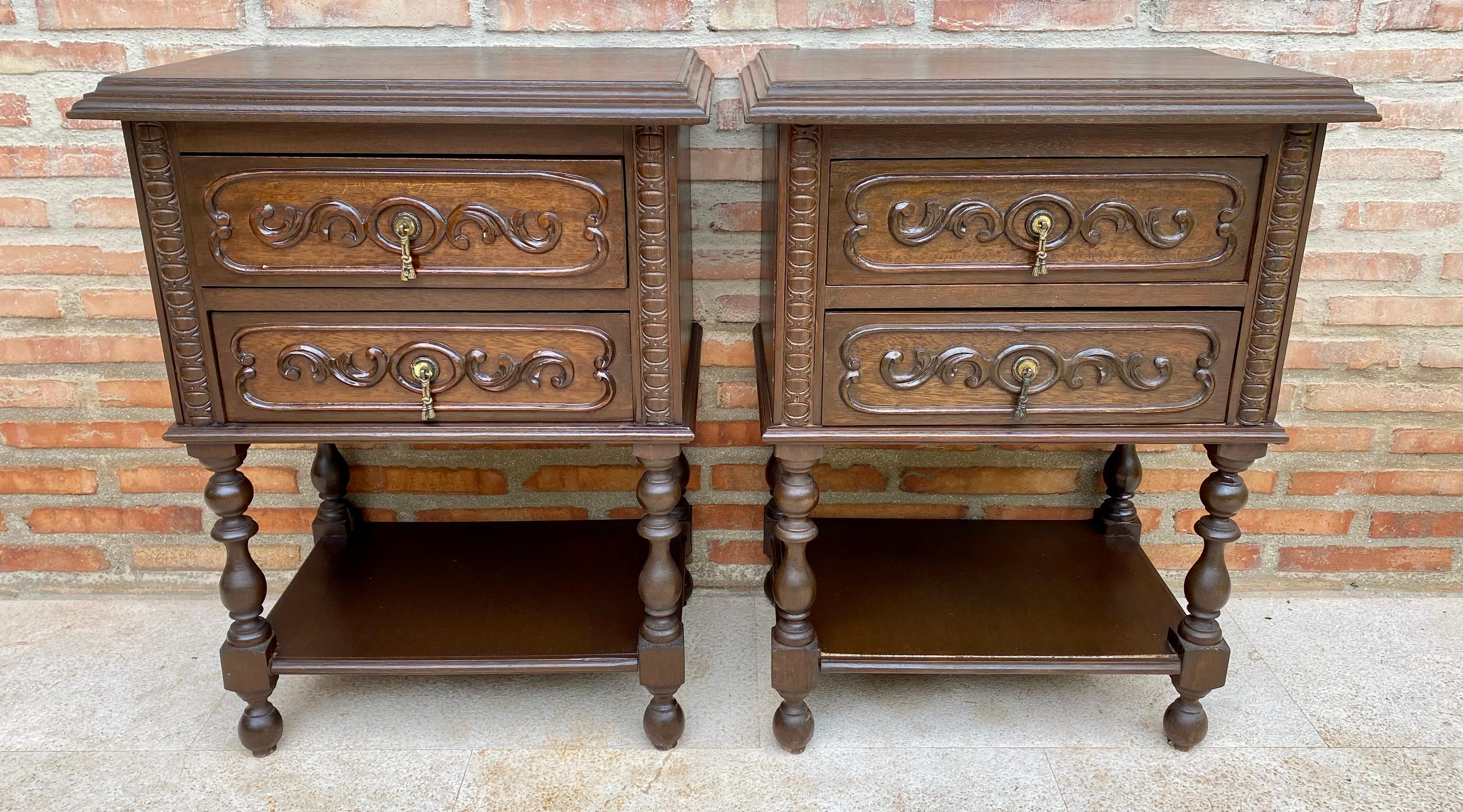 20th century pair of solid carved French nightstands with turned columns, two drawers and one low shelve. 
It has two carved drawers with original bronze pulls.