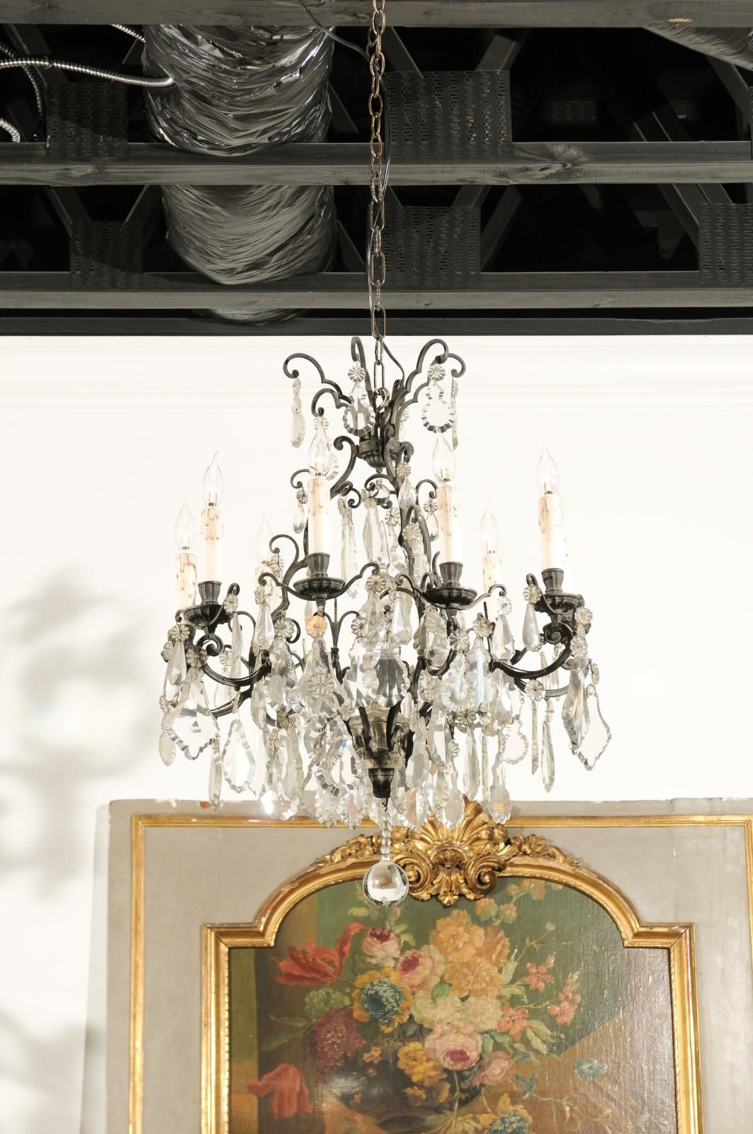 A French nine-light crystal chandelier from the late 19th century, with iron armature and pendeloques. Born in France during the later years of the 19th century, this handsome chandelier features an iron armature supporting pendeloques and rosettes.