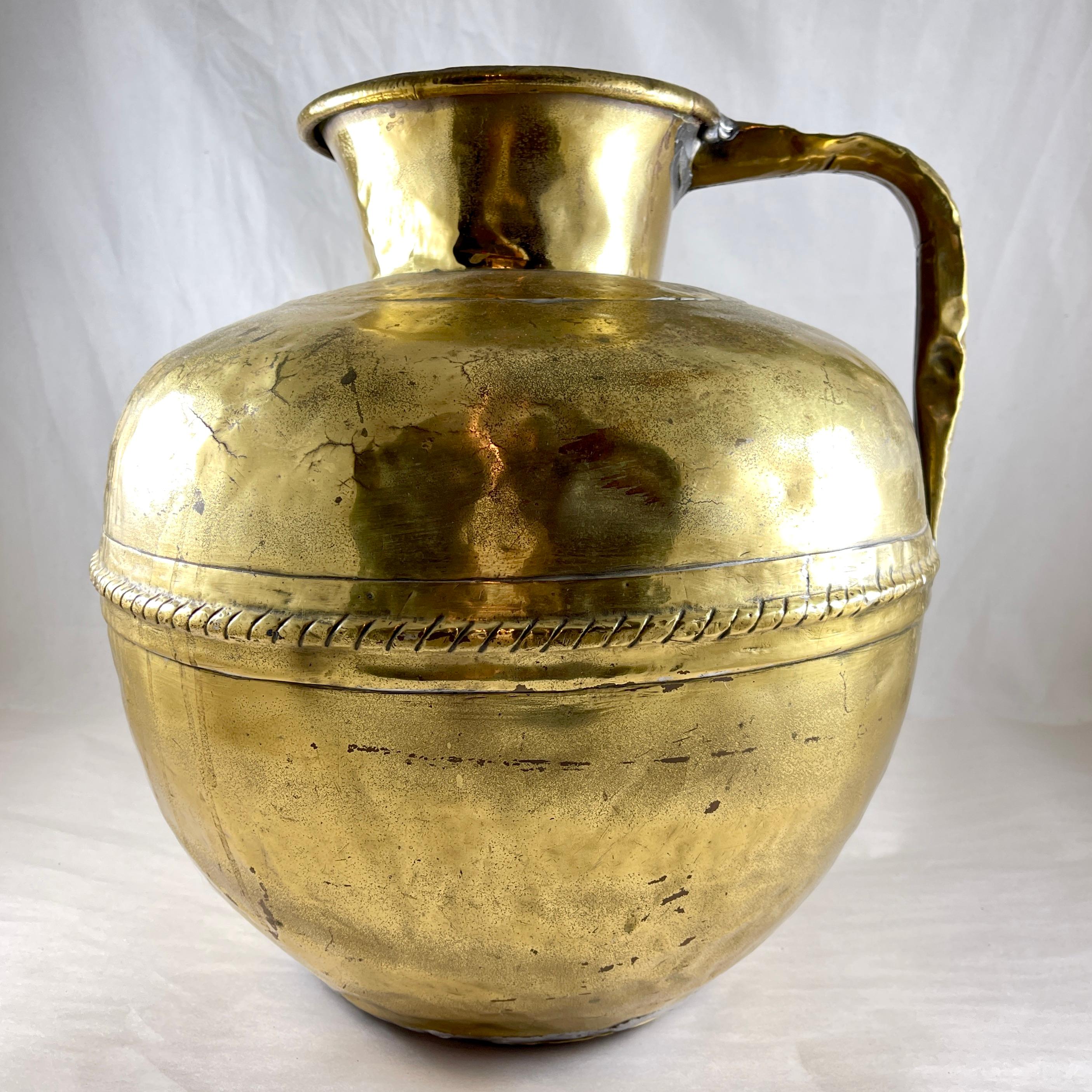 
A rustic hand hammered Brass Milk Jug from Normandy, France, Circa 1850

A large piece of hand made brass used to transport milk from the country dairy to the home, often by donkey. 

The outer body shows the textured surface left by the hammering