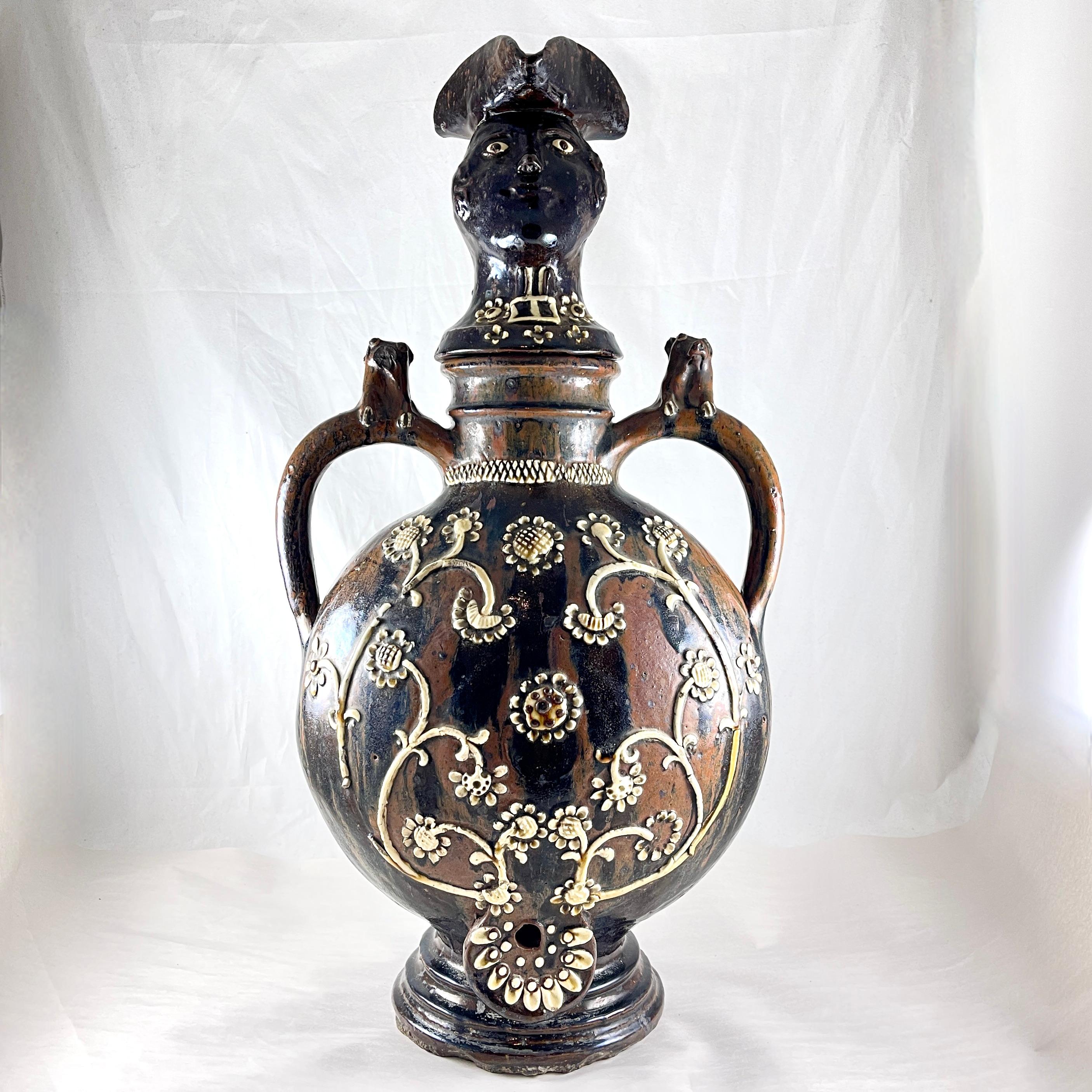 A large and heavy Vindefontaine Beverage Fountain, Normandy, France, circa 1840 – 1850.

Referred to as a fountain, this vessel was used for the storing and serving of water or wine. Glazed in a treacle glazed earthenware of brown and black with a
