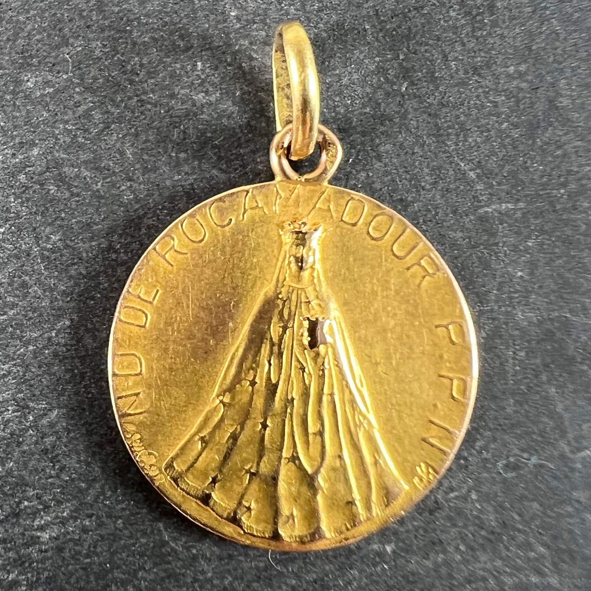 Colgante de oro amarillo de 18 quilates (18K) diseñado como una medalla que representa a la Virgen María con un vestido que se asemeja a una alta montaña con la frase 