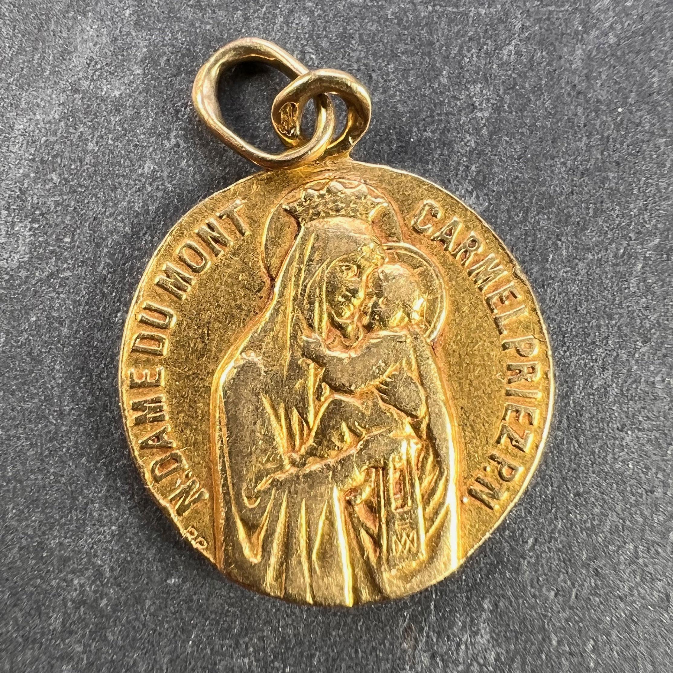 An 18 karat (18K) yellow gold charm pendant designed as a medal depicting the Madonna and Child with the phrase ‘N.Dame (Notre Dame) Du Mont Carmel Priez PN (Pour Nous)’ (trans. Our Lady of Mount Carmel Pray for Us) around the edge. 

The reverse