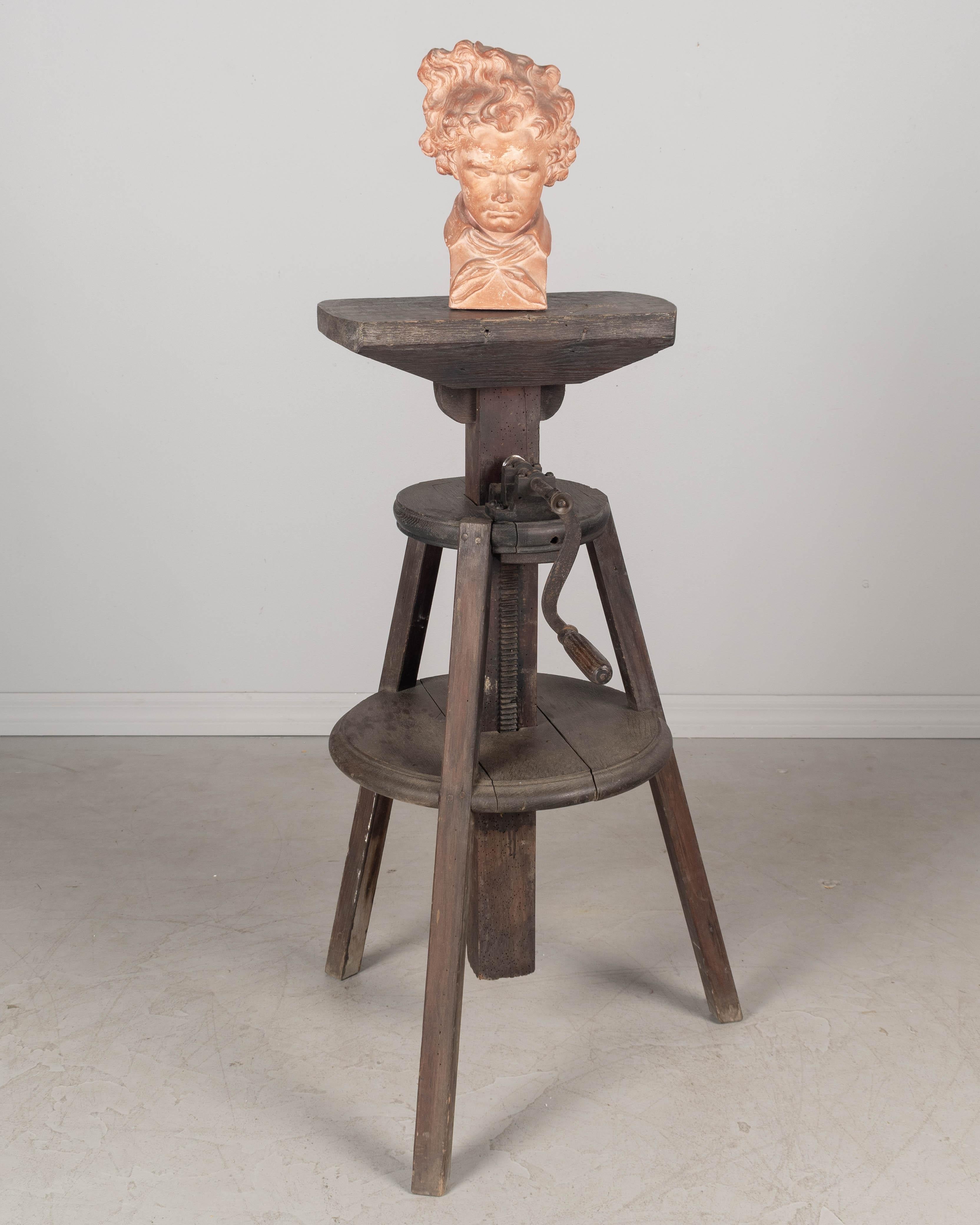Un cavalletto da scultore regolabile francese del XIX secolo realizzato in rovere massiccio con finitura scura. Piano rettangolare e robusta base a treppiede con gambe distanziate. La manovella in ghisa con manico in legno regola l'altezza. Un