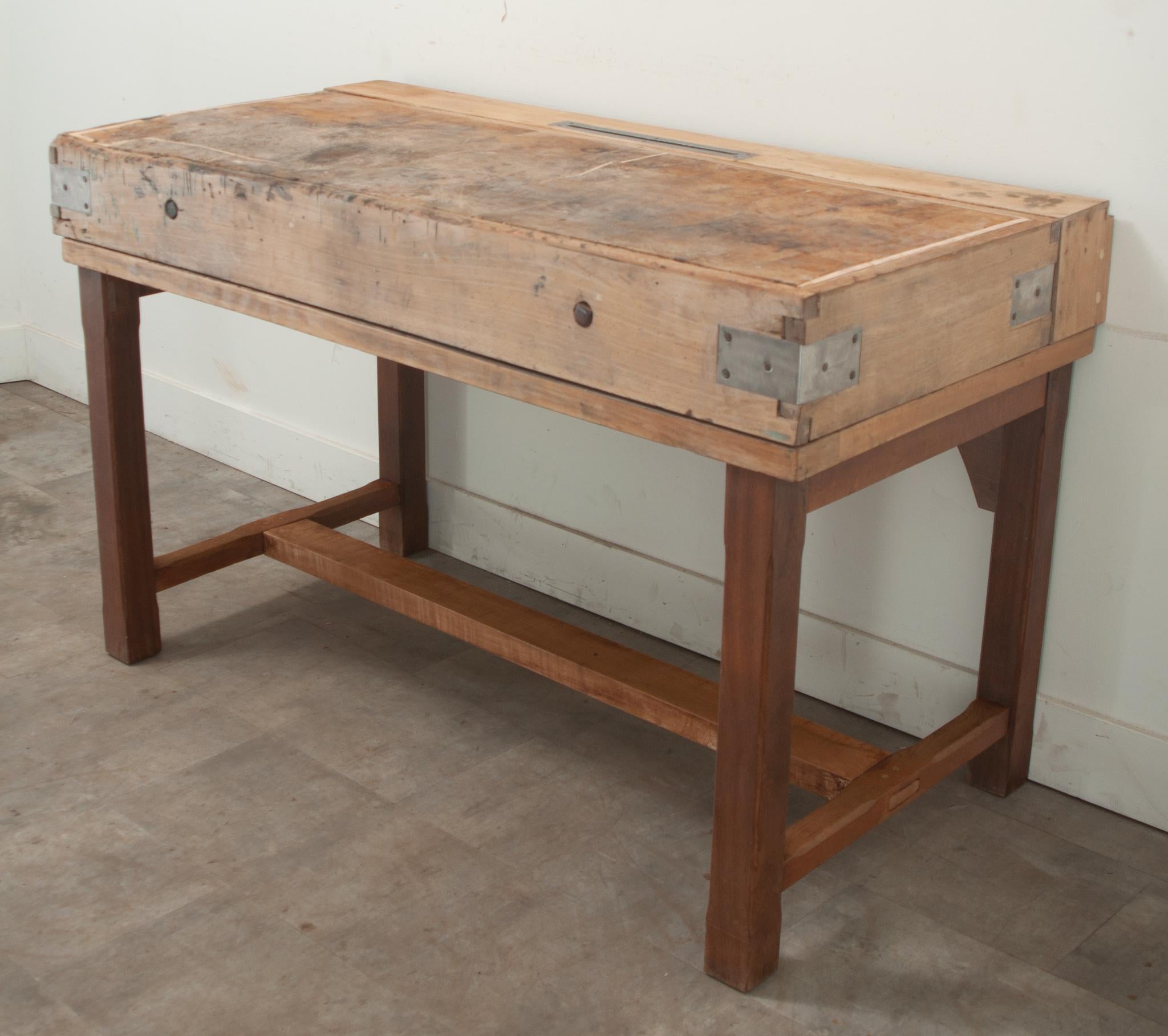 A French hand-built butcher block table made from oak and pine would make the perfect kitchen island. This functional antique has a thick top made of many wood fragments all held together with steel bindings. On the top surface you’ll find a lined