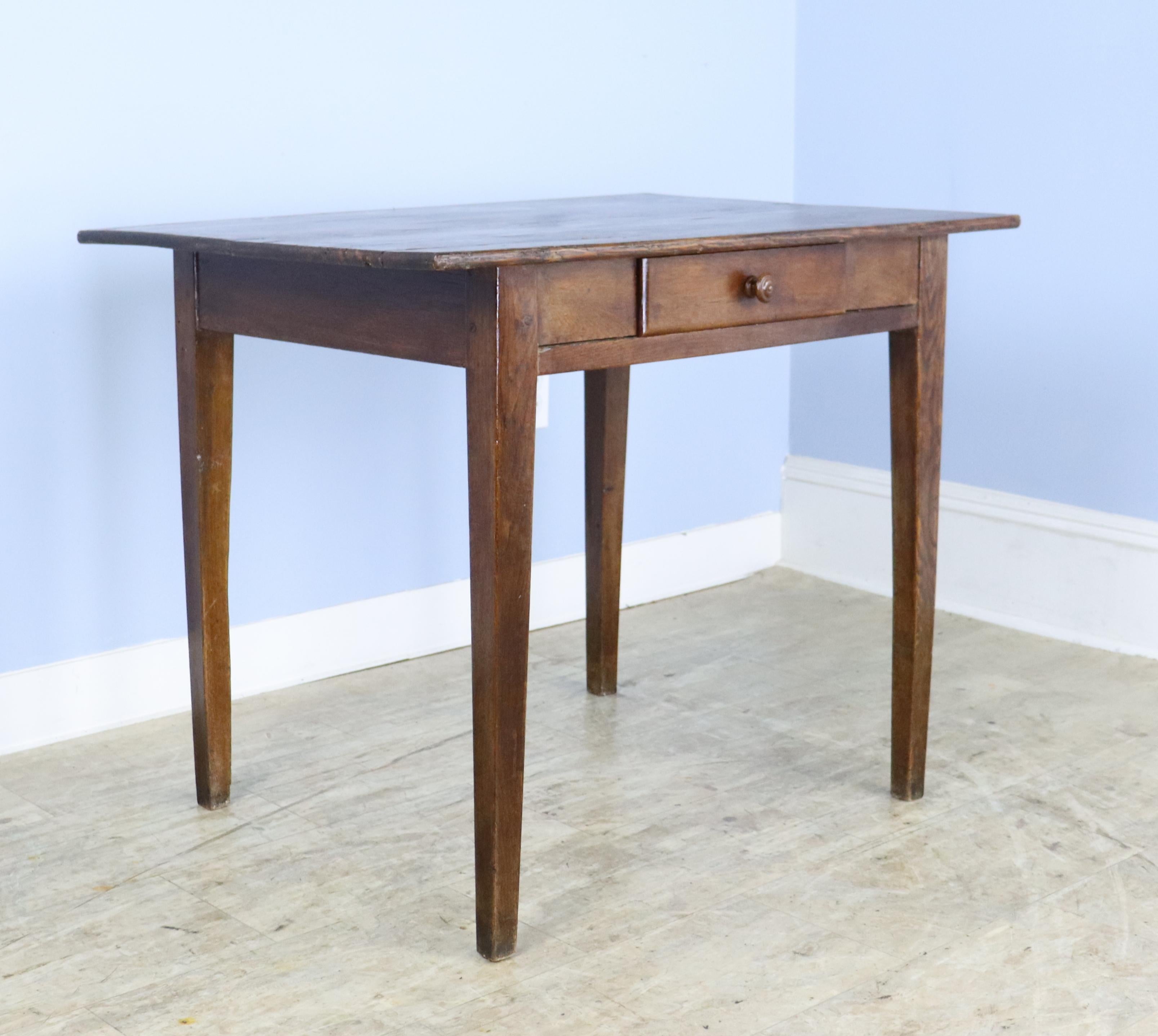 A side table with a pine top and oak base. It has a very simple silhouette, and with an almost 24