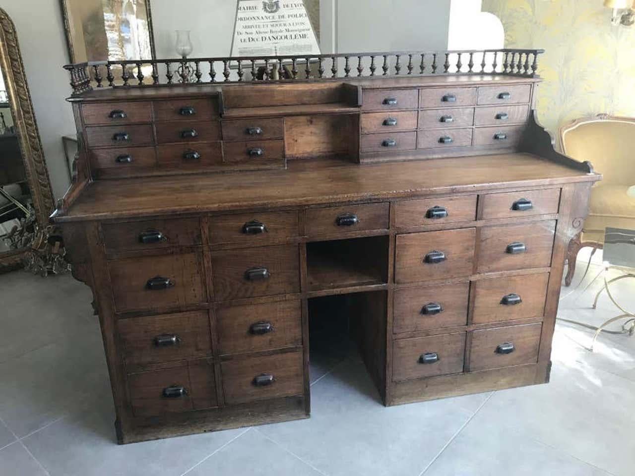 Exceptional French oak antique apothecary and pharmacy cabinet from the 1900s. 
There are two parts, one part is intended for the customer and the other part is intended for the seller. 
There is a mirror on the customer part. Missing a glass
