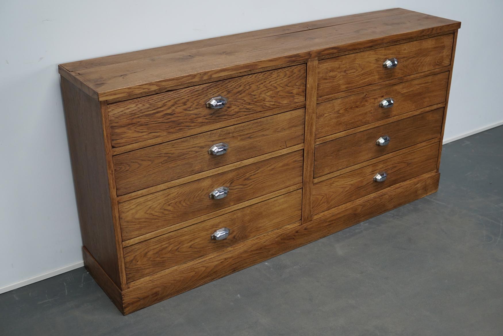 This apothecary cabinet of drawers was designed, circa 1930s in France. The piece is made from oak and features 8 drawers with Art Deco style hardware. The interior dimensions of the drawers are: 27.5 D x 71.5 W x 12.5 H cm.