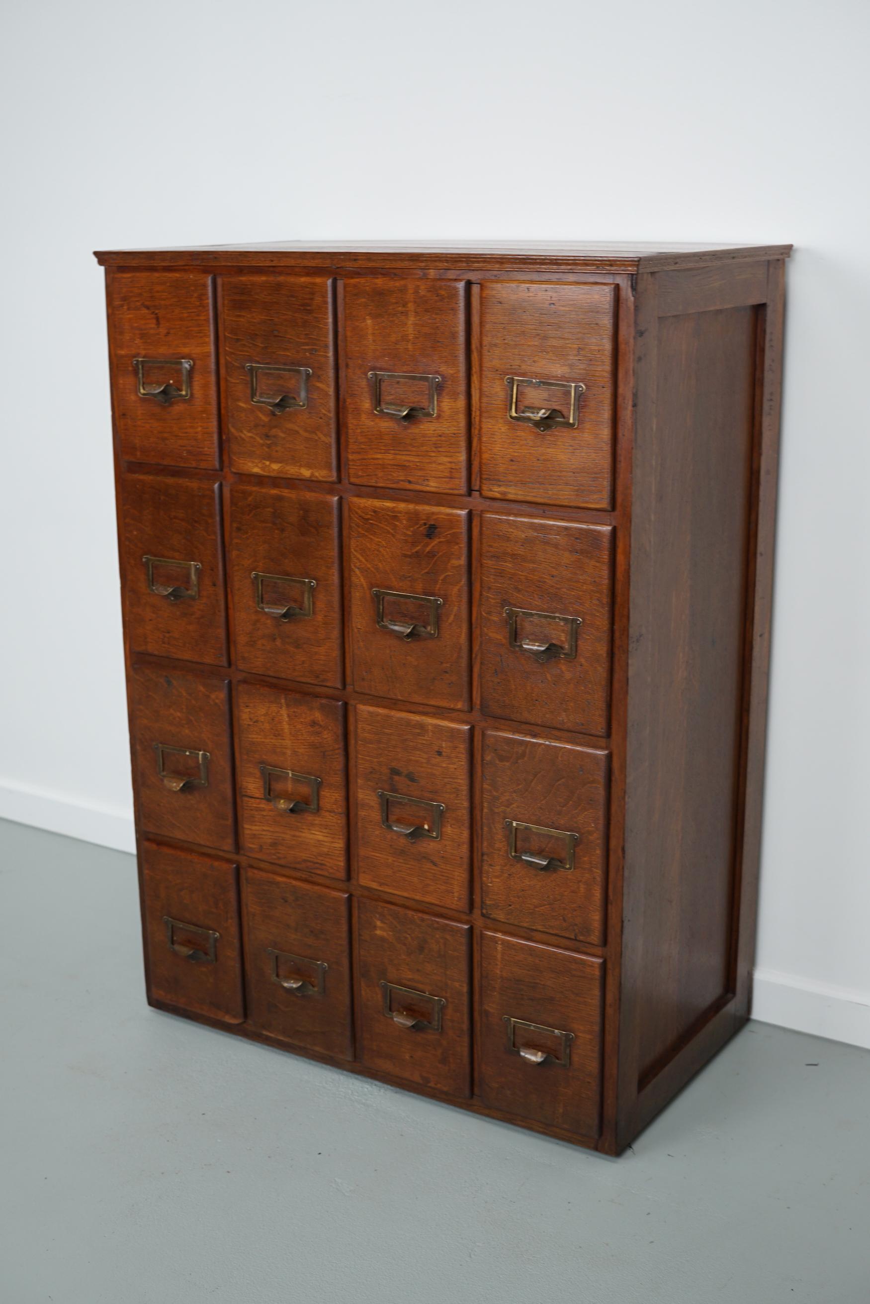 This apothecary / filing cabinet was produced during the 1920/30s in France. It features 16 drawers from oak with brass pulls. The interior dimensions of the drawers are: D x W x H 35 x 12 x 8.5 / 20 cm.