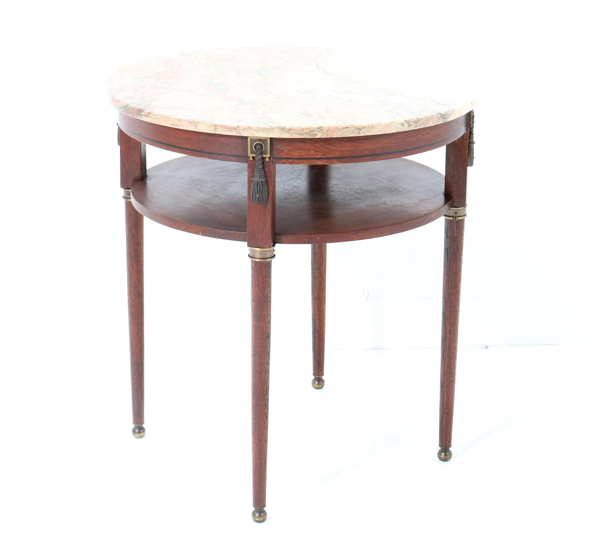 Amazing and rare Art Deco side table or center table.
Striking French design from the 1930s.
Solid oak and original oak veneer base with original patinated brass elements.
Original multi-colored marble top.
This wonderful Art Deco side table or