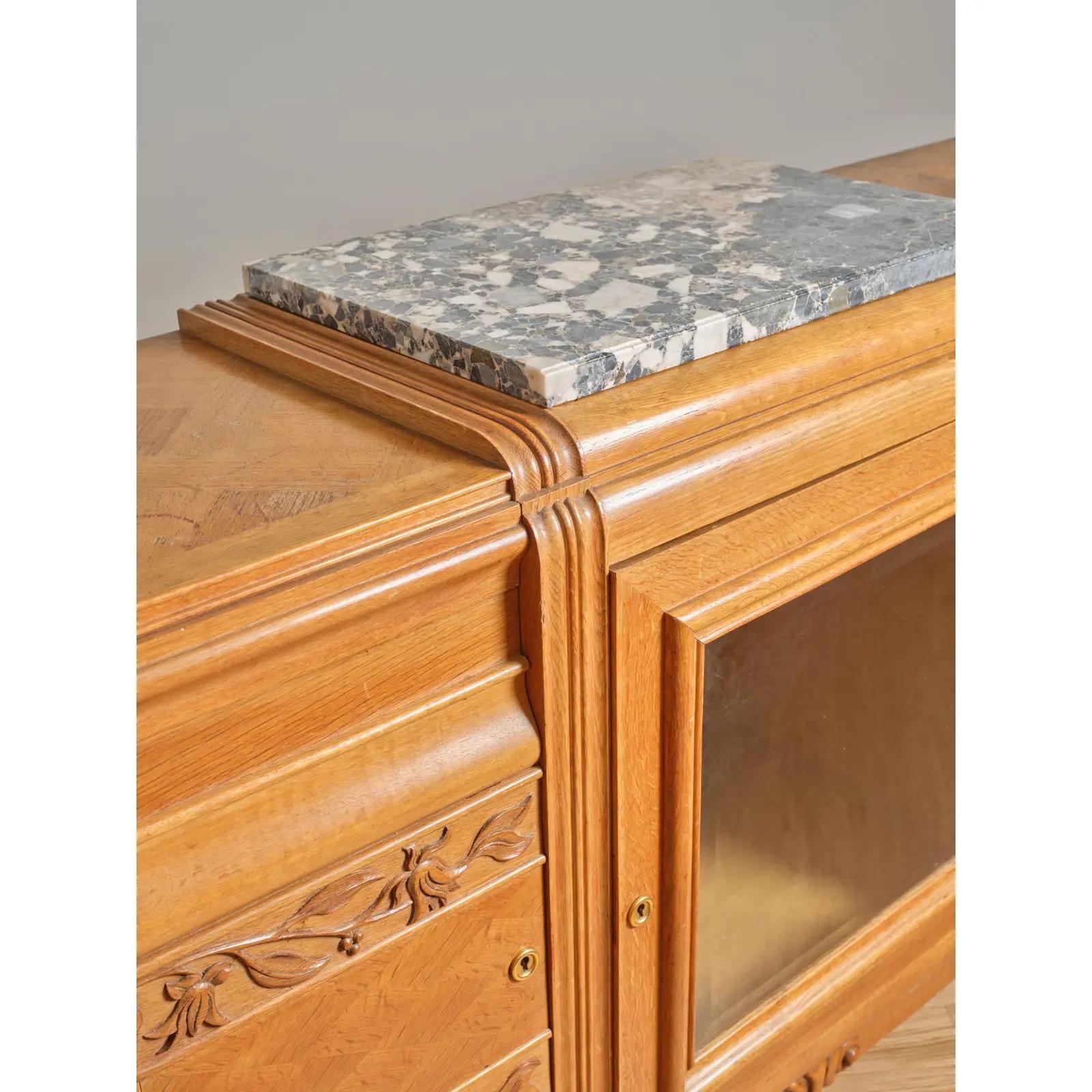 French oak Art Deco sideboard with partial marble top and central bar cabinet with inside shelving and glass door. Marble top comes off. 
C 1935.