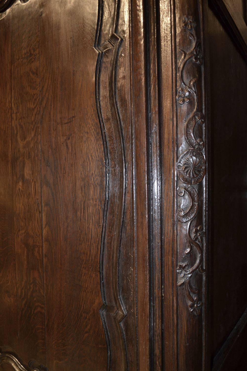 This piece dates from the early part of the 19th century. It has nicely carved feet rising into vertical stiles with more carvings. The door has three exuberantly carved door panels and the scale of the piece is particularly elegant. The cabinet has