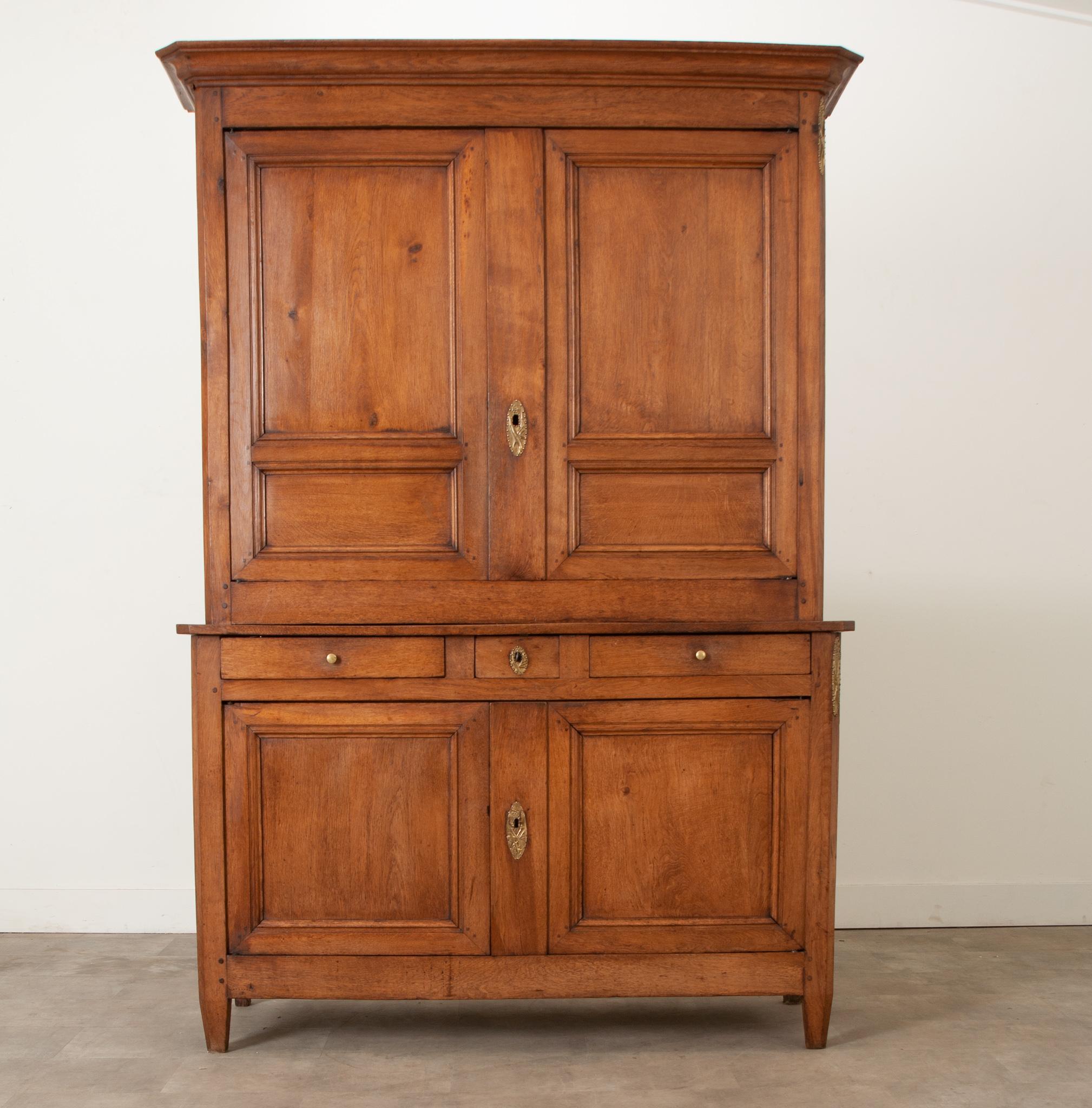 A gorgeous oak buffet à deux corps was hand built in the 1800's from solid light oak. Simple in style this paneled buffet is unique and practical. The top half of the buffet is 51 ¼”D with two paneled door fronts and two interior fixed shelves
