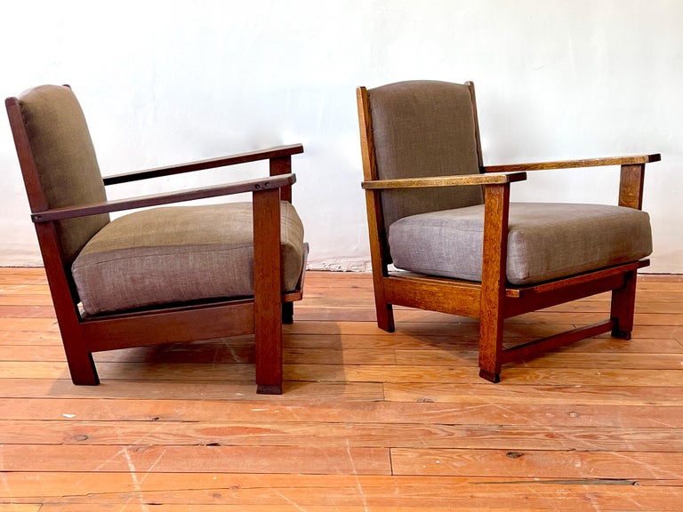 Handsome pair of French Oak chairs with simple lines and clean chocolate linen upholstery.  

Brass tack detailing with slightly curved seat back shape. 

Wonderful rich patina'd oak. 