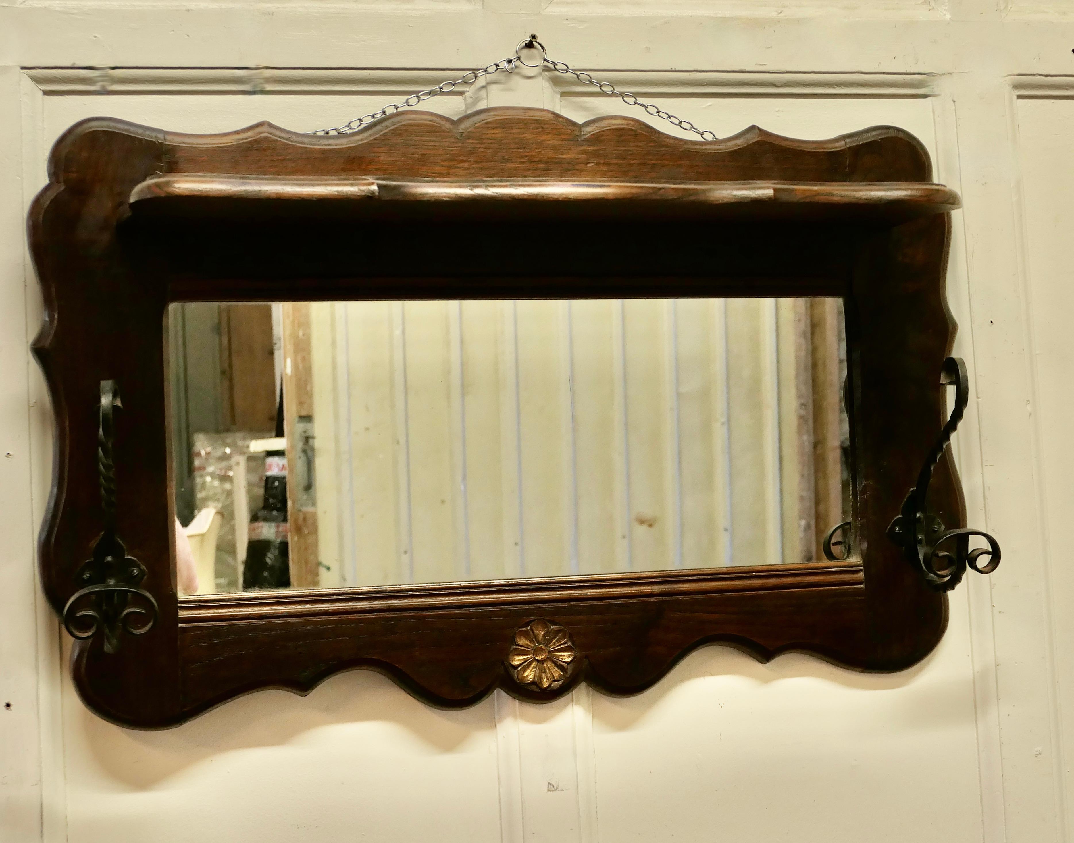 French oak coat and hat rack with shelf and mirror.

The rack is made in solid oak, it has a hat shelf at the top and a mirror below and beneath these are 2 large S shaped blacksmith made double wrought iron coat hooks, good for coats or