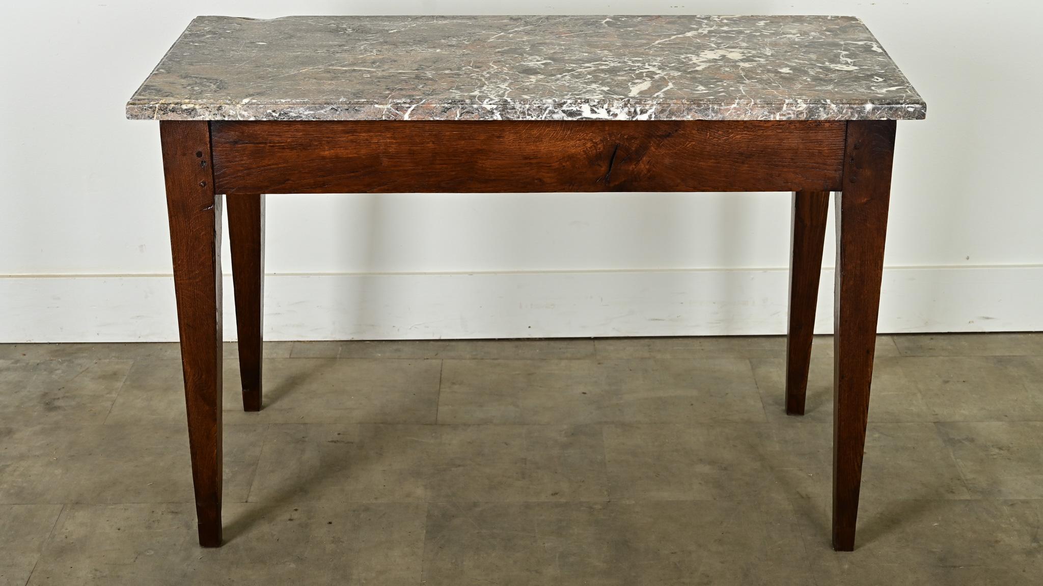 Crafted in France circa 1850,  this unique console table is topped with an impressive slab of marble - chiseled by hand - which rests on a solid oak base. In the apron one can see the joinery technique of wooden pegs. The wonderfully patinated