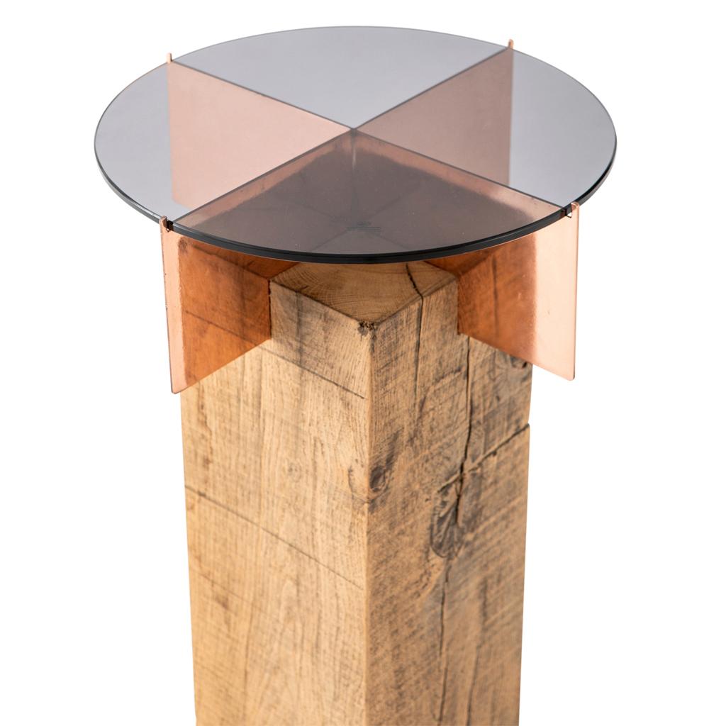 The jewel TOTEM side table is part of a series of small cocktail tables by Egg Designs.
This version is a combination of copper-plated steel, solid French Oak bunt and smokey glass. The design is inspired by a ring with the lass representing the