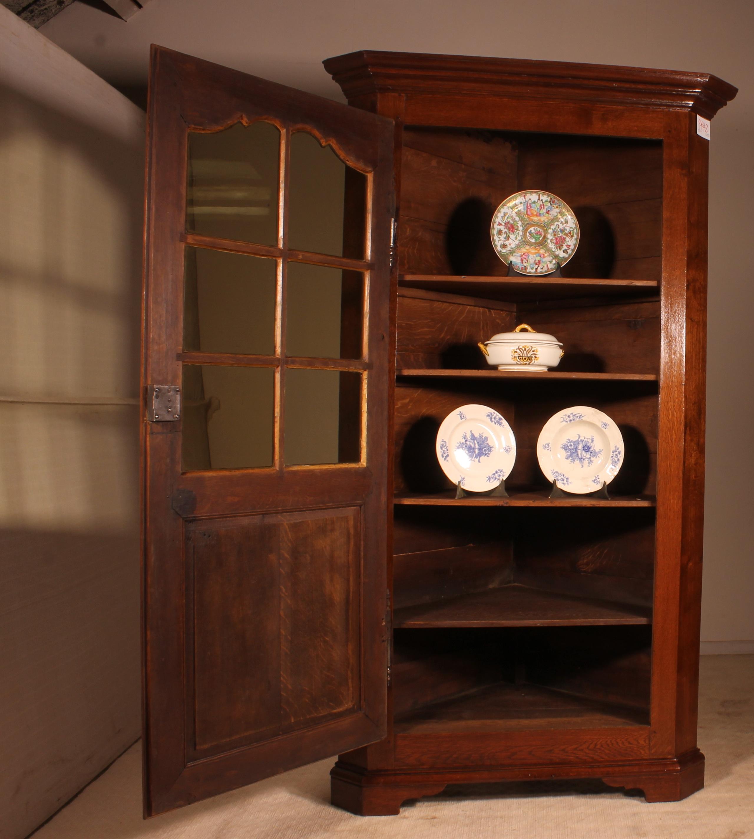 Lovely French corner cupboard in oak partly from the 18th century 
Very nice corner cupboard with windows and a lovely cornice 
Very nice piece in perfect condition that has shelves (if necessary, it is possible to remove one or more shelves)