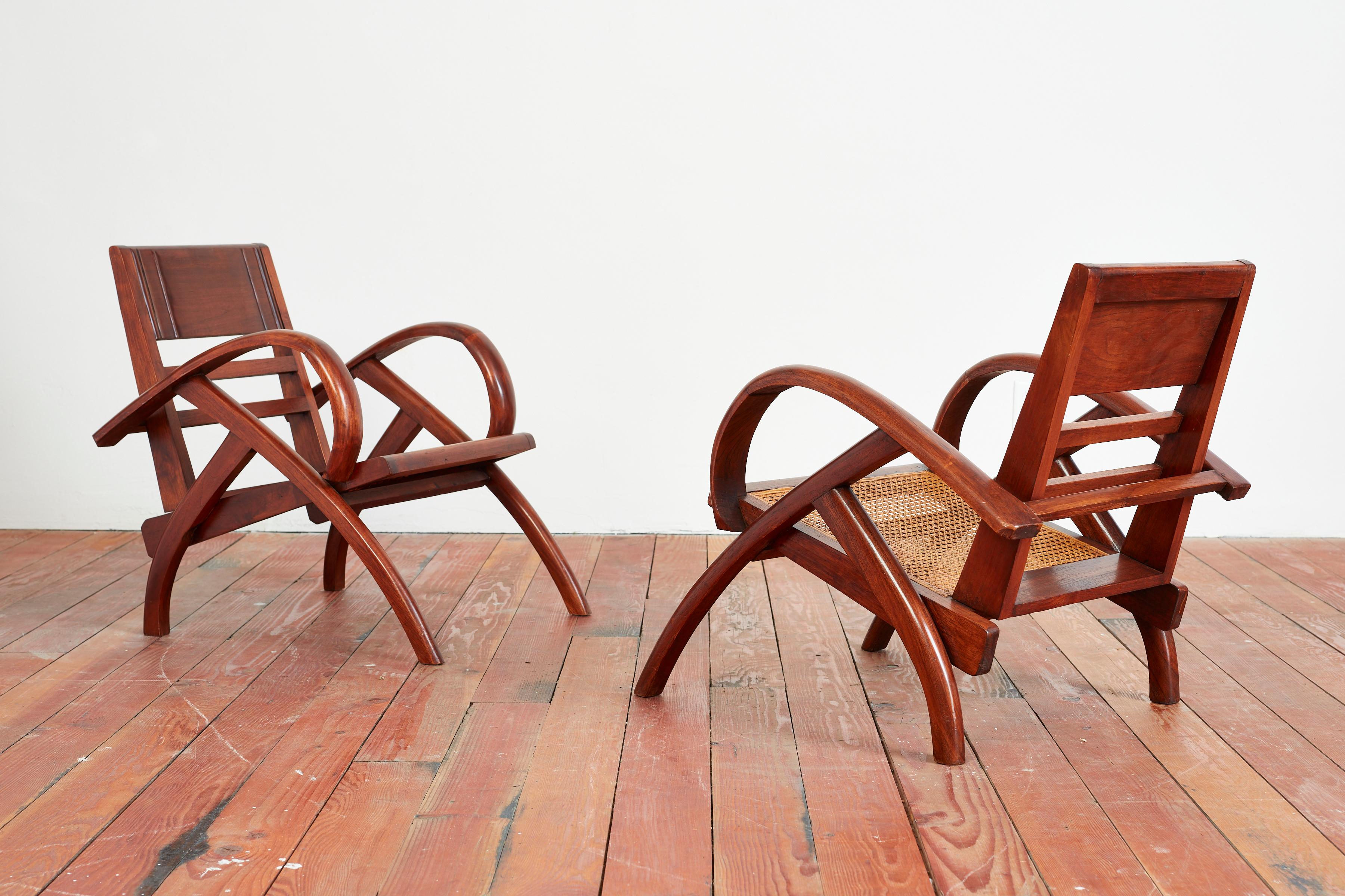 Unique pair of French caned folding chairs with sculptural lines and wonderful patina.
Caned seat with seatback that folds forward to rest on seat 
France, circa 1950s.