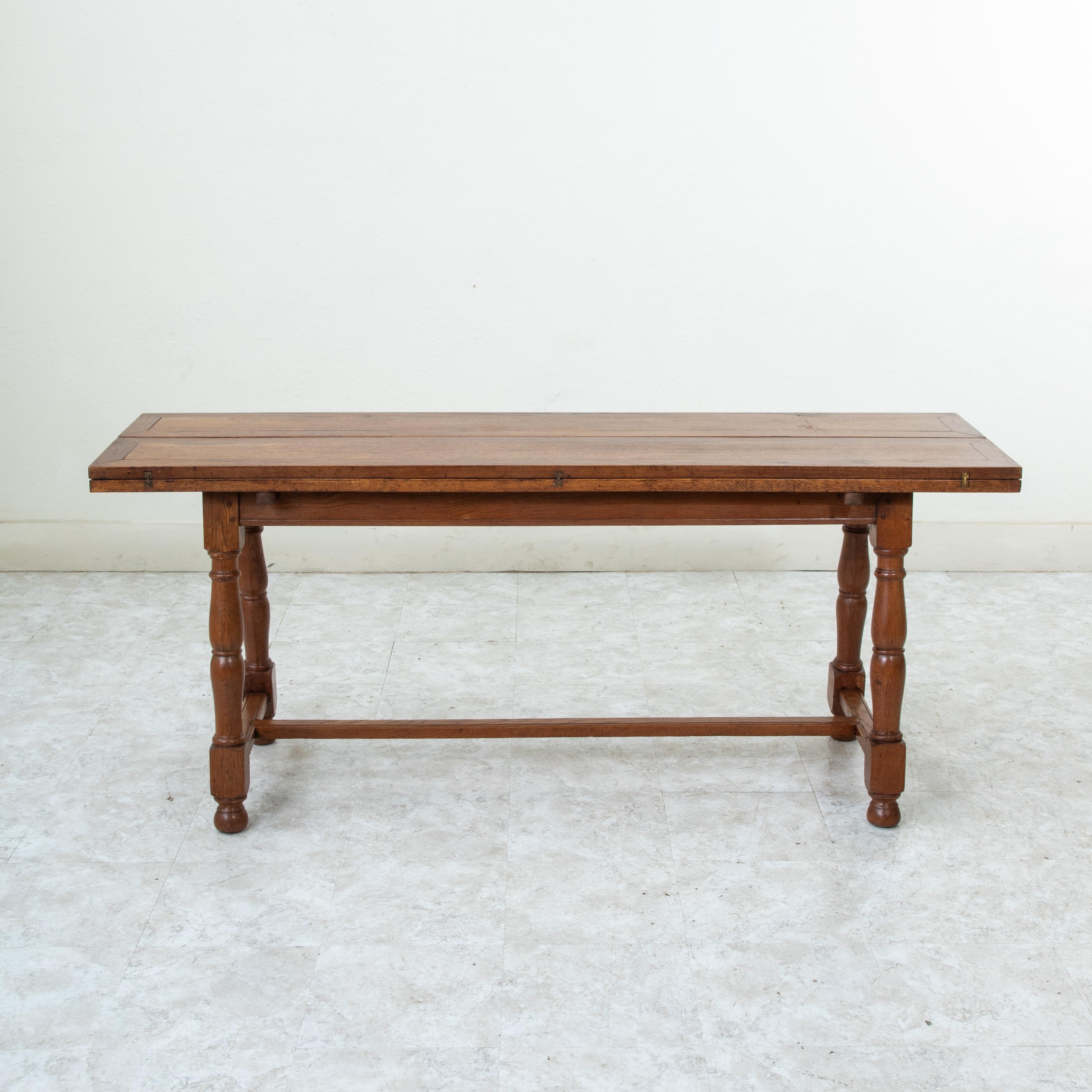 Called a table de chasse in French, or hunt table, this French oak table from the turn of the twentieth century was originally designed to lay out the game after the hunt and features a hinged top that allows the surface to double in width when