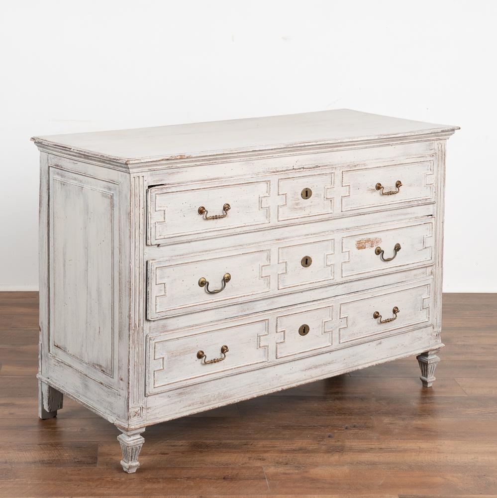 Large chest of three drawers with carved panels from France, circa 1820-1840.
The newer, professionally applied soft gray painted finish (with blue and white undertones) adds a touch of life and interest to this heavy oak chest.
The carved panel