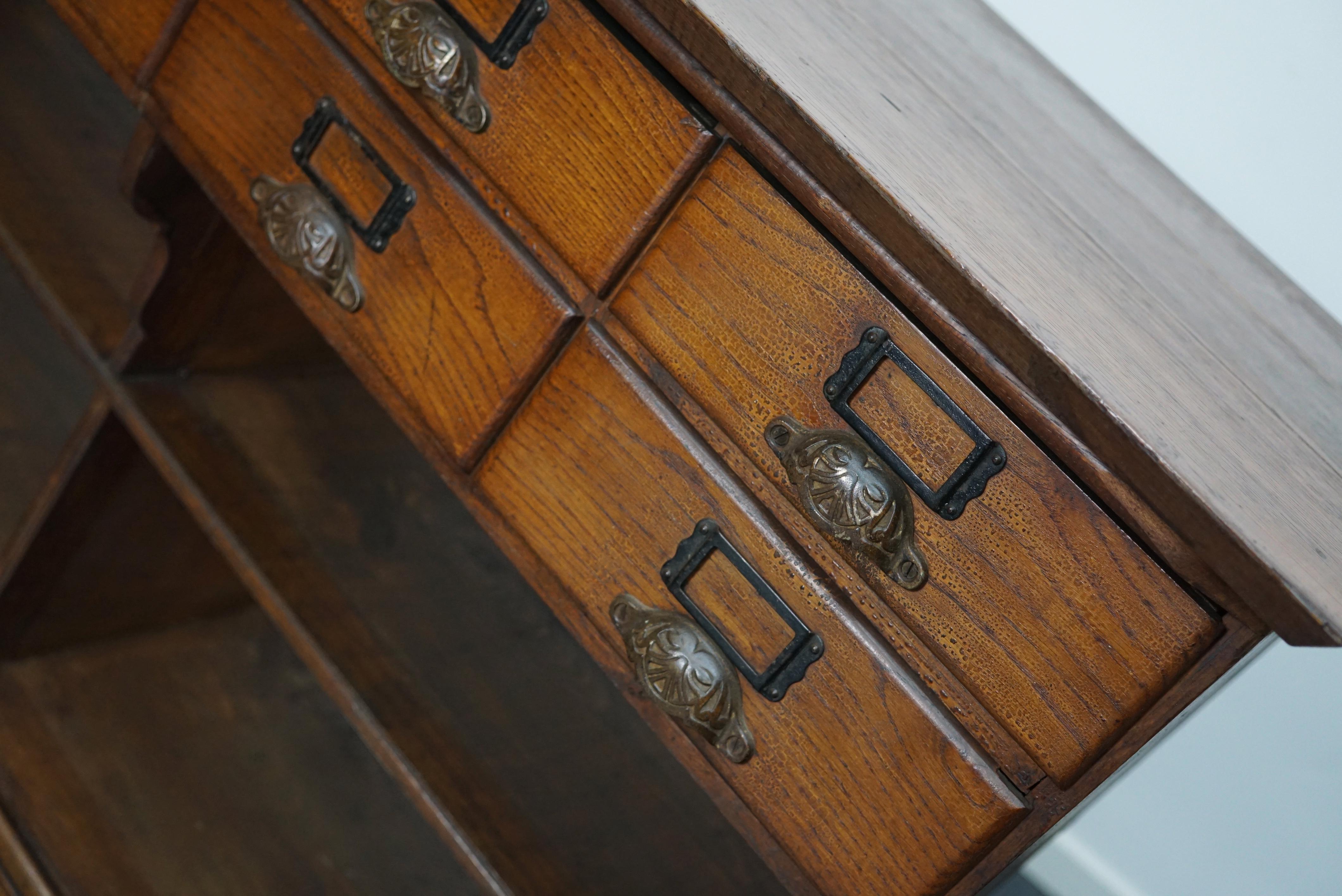 Nice 19th century French oak cabinet most likely from a general store to display items. It features drawers with cast iron handles in the top and shelves in the bottom. The cabinet has retained a very rich patina over the years. The interior