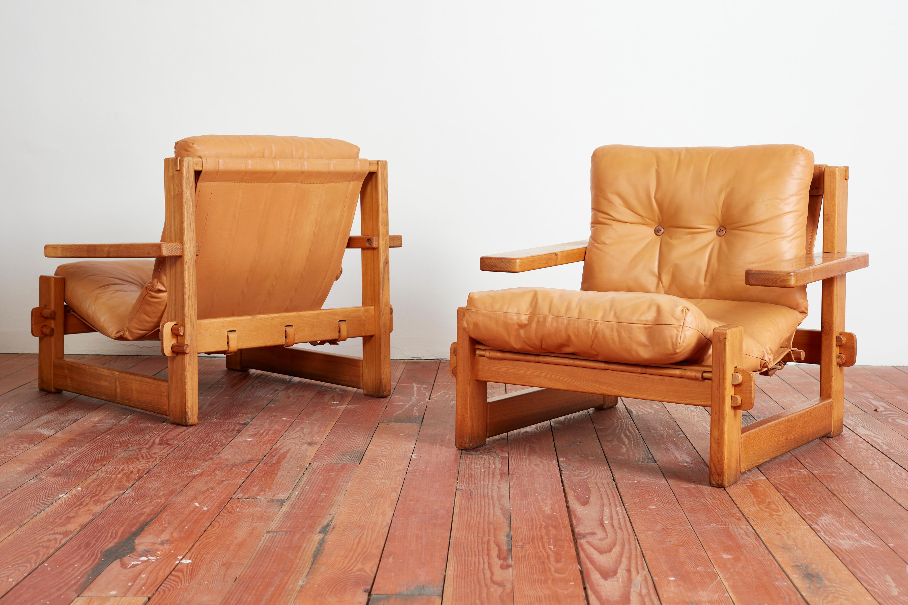 Unique cubist shaped oak chairs with cantilevered paddle arms and leather sling cushions. 
Wonderful construction with doweling holding the frame 
Butterscotch original leather has been restored and visible from all sides 
Back buckle