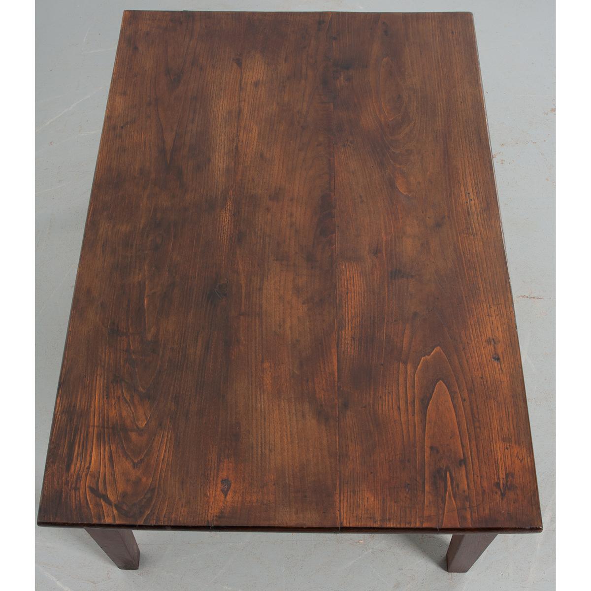 This rich oak coffee table is from France circa 1860. The smooth, waxed top is constructed of three boards that highlight the rings of the tree from which the table was constructed over 160 years ago. The thick apron is fitted with one working