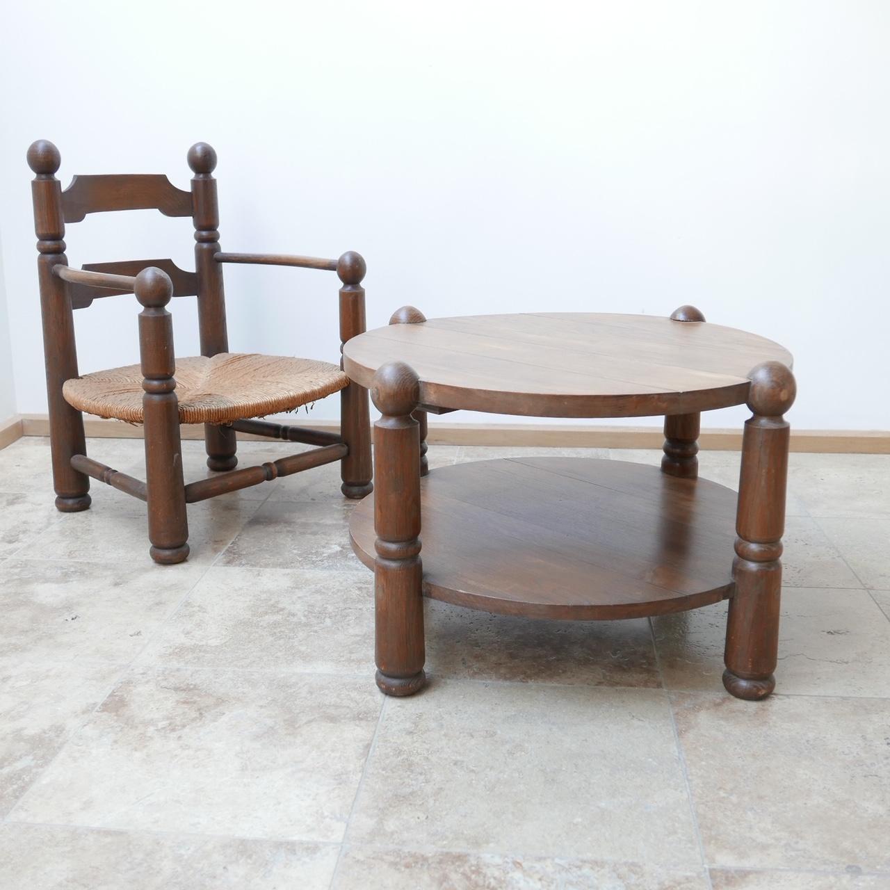 An oak midcentury table in the manner of Charles Dudouyt. 

French, circa 1940s. 

Two-tier. 

Superb functinality and form. 

Dimensions: 69 diameter x 47 height in cm.