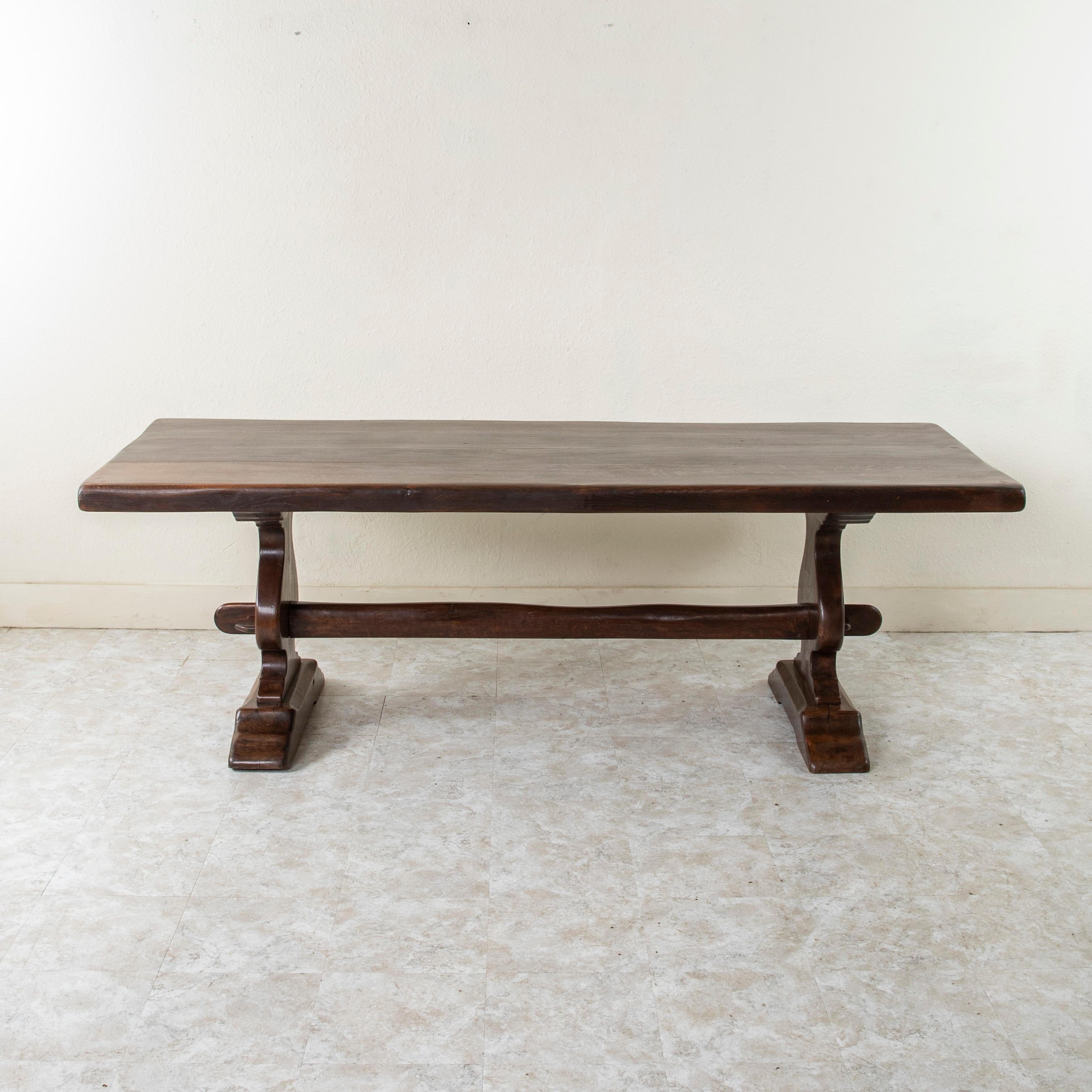 Dieser große, handgefertigte Klostertisch oder Esstisch aus Eiche von der Jahrhundertwende in der Normandie, Frankreich, hat eine 2,5 Zoll dicke Platte, die aus vier Holzbrettern besteht. Drei Keilnuten verlaufen über die gesamte Länge des Tisches,