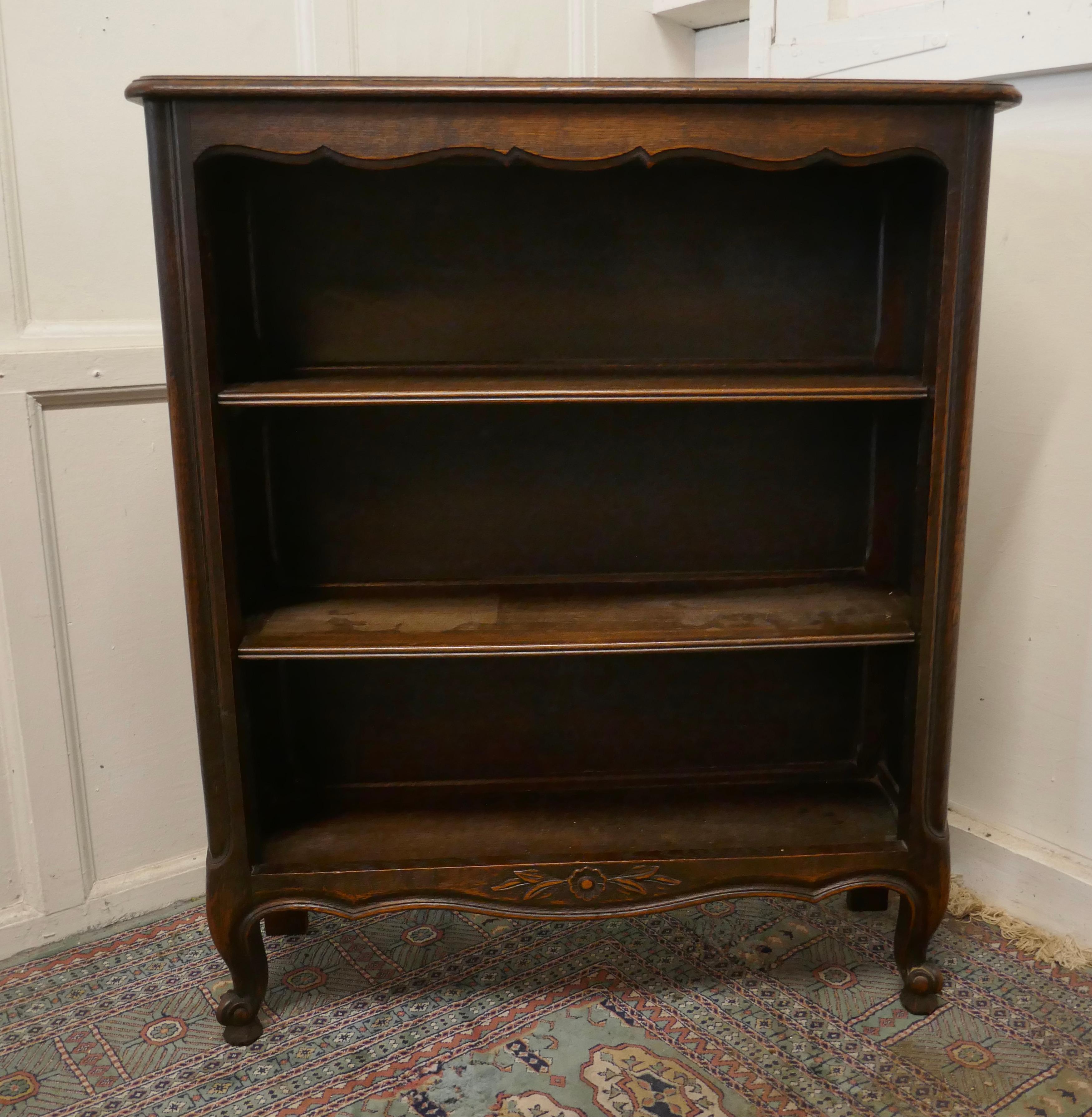 French oak open bookcase

This is a useful piece, it is made in oak and stands on short cabriole legs with a small carved decoration at the bottom
The bookcase has 2 moveable shelves the shelf is in good condition 
The book case is 39” high, 33”