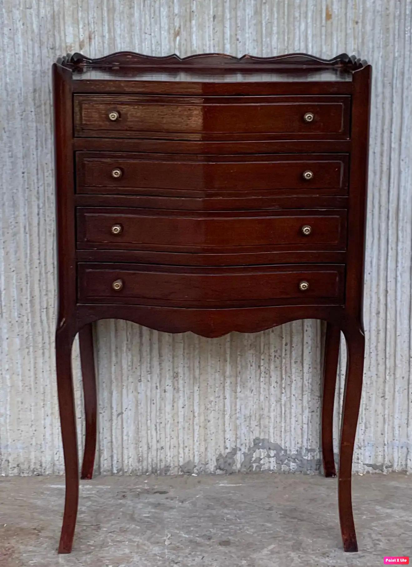A French oak bedside table with four drawers from the late 19th century. This French 'table de chevet' features a rectangular top surrounded by a three-quarter wooden gallery, sitting above the drawers, all opening with wood pulls. The sides are