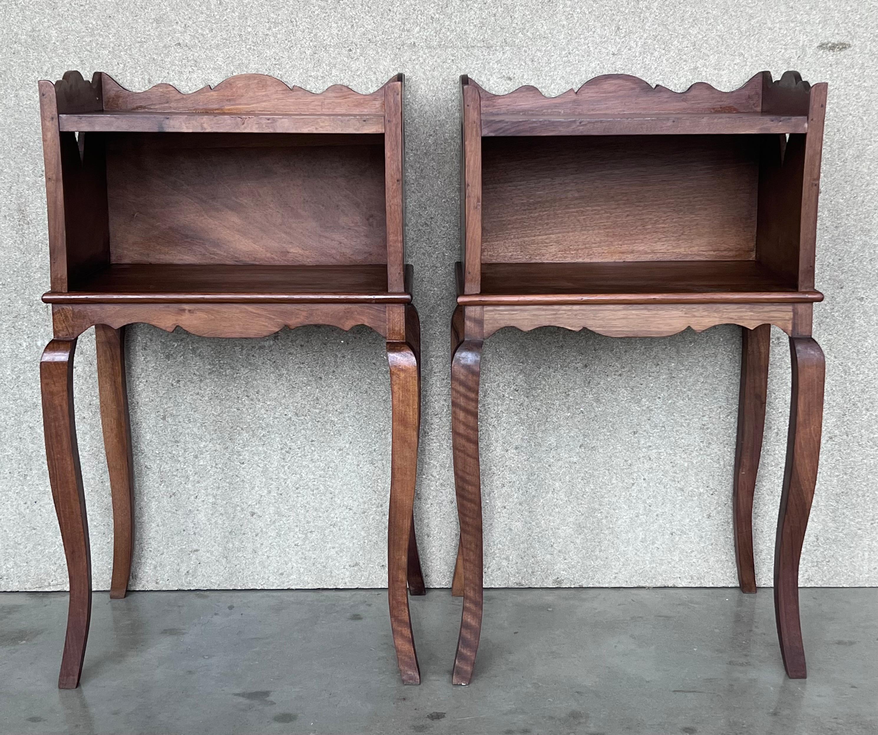 A French oak bedside table with open shelf from the late 19th century. This French 'table de chevet' features a rectangular top surrounded by a three-quarter wooden gallery with two hearts one in each side. It has an open shelf perfect for books and