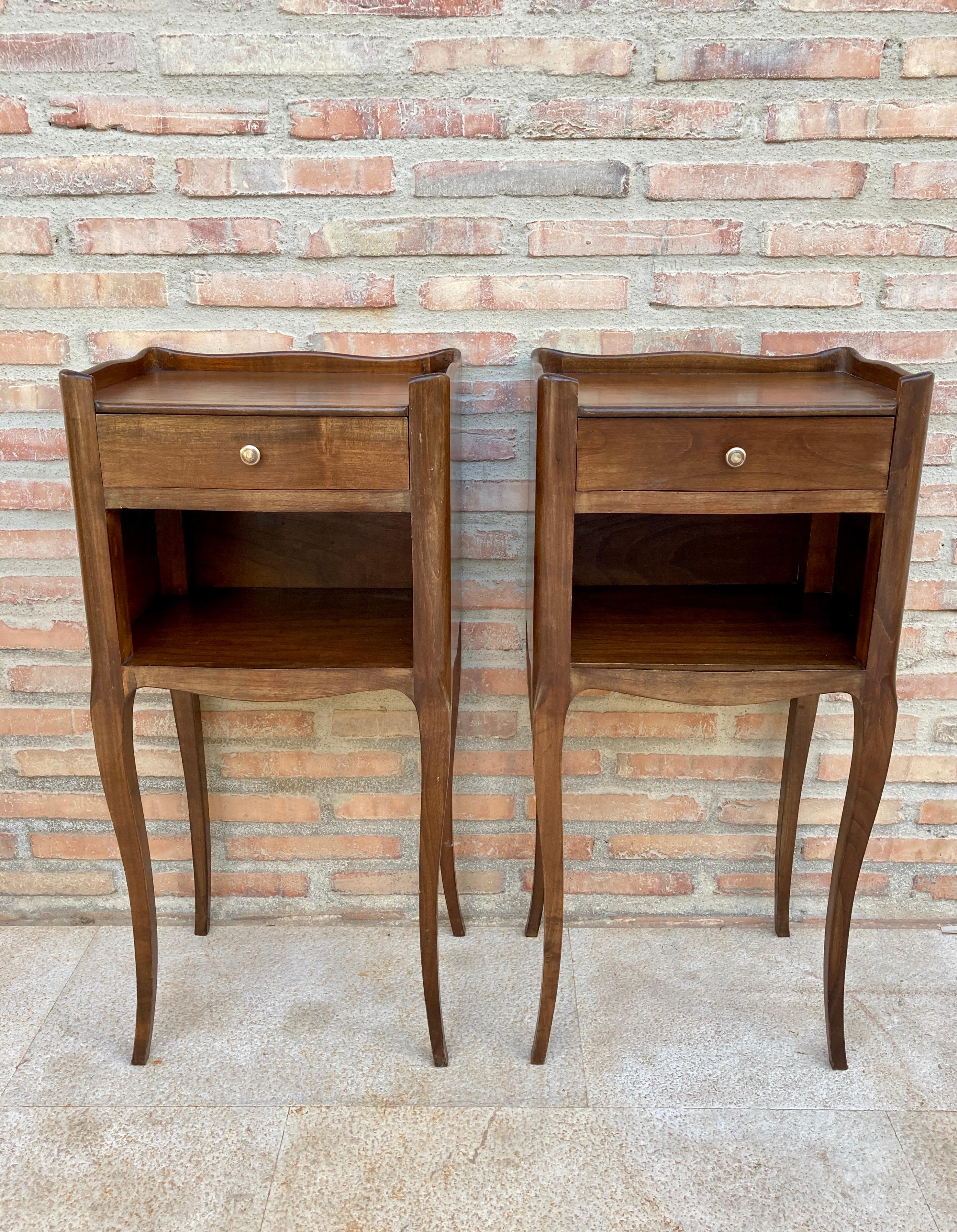 A French oak bedside table with one drawer from the late 19th century. This French 'table de chevet' features a rectangular top surrounded by a three-quarter wooden gallery, sitting above a drawer, all opening with wood pulls. It has an open shelf