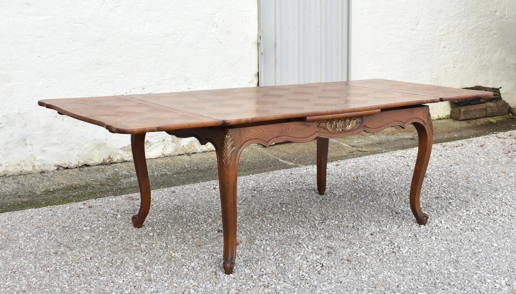 Table de salle à manger en chêne français à plateau en parqueterie 

Cette belle table de salle à manger en chêne français est dotée d'un plateau en parquet en trois parties, dont deux allonges qui se rangent sous le plateau lorsqu'elles ne sont pas