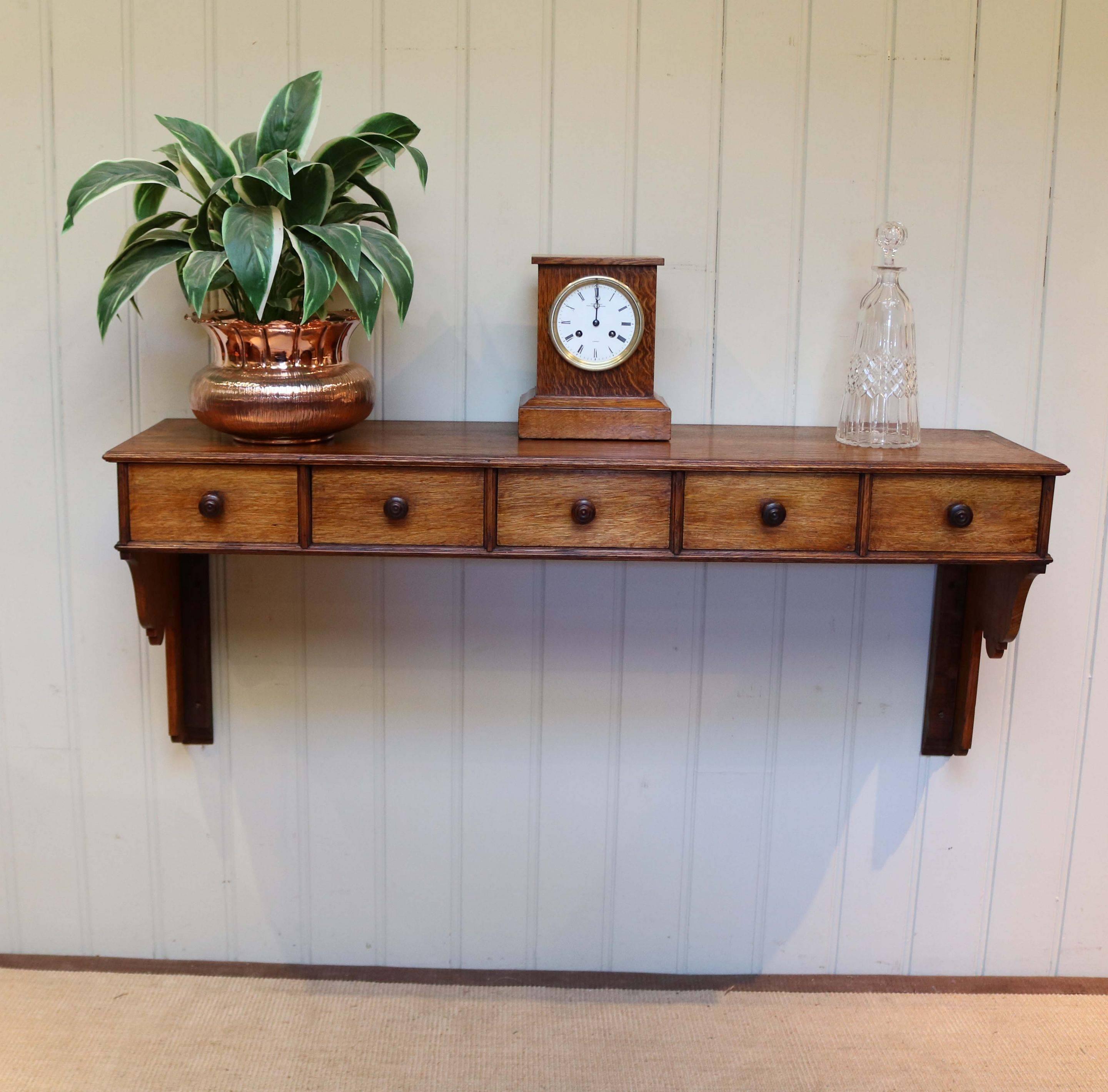 French oak wall shelf with five drawers having turned wooden handles and shaped supports. Could be used as a hall table if mounted lower would suit somewhere with deep/thick skirting boards.