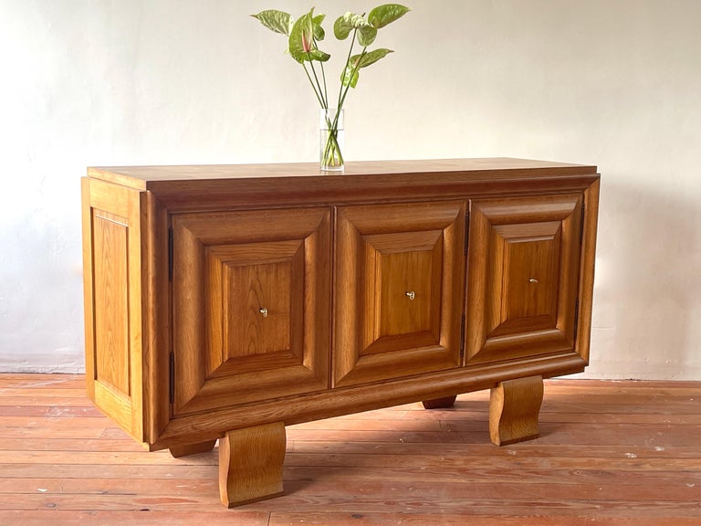 Elegant oak sideboard with rich patina and simple lines.
1940's France 
Graceful curved legs with 3 panel doors open to shelving. 
Wonderful grain to wood with checkboard top 
