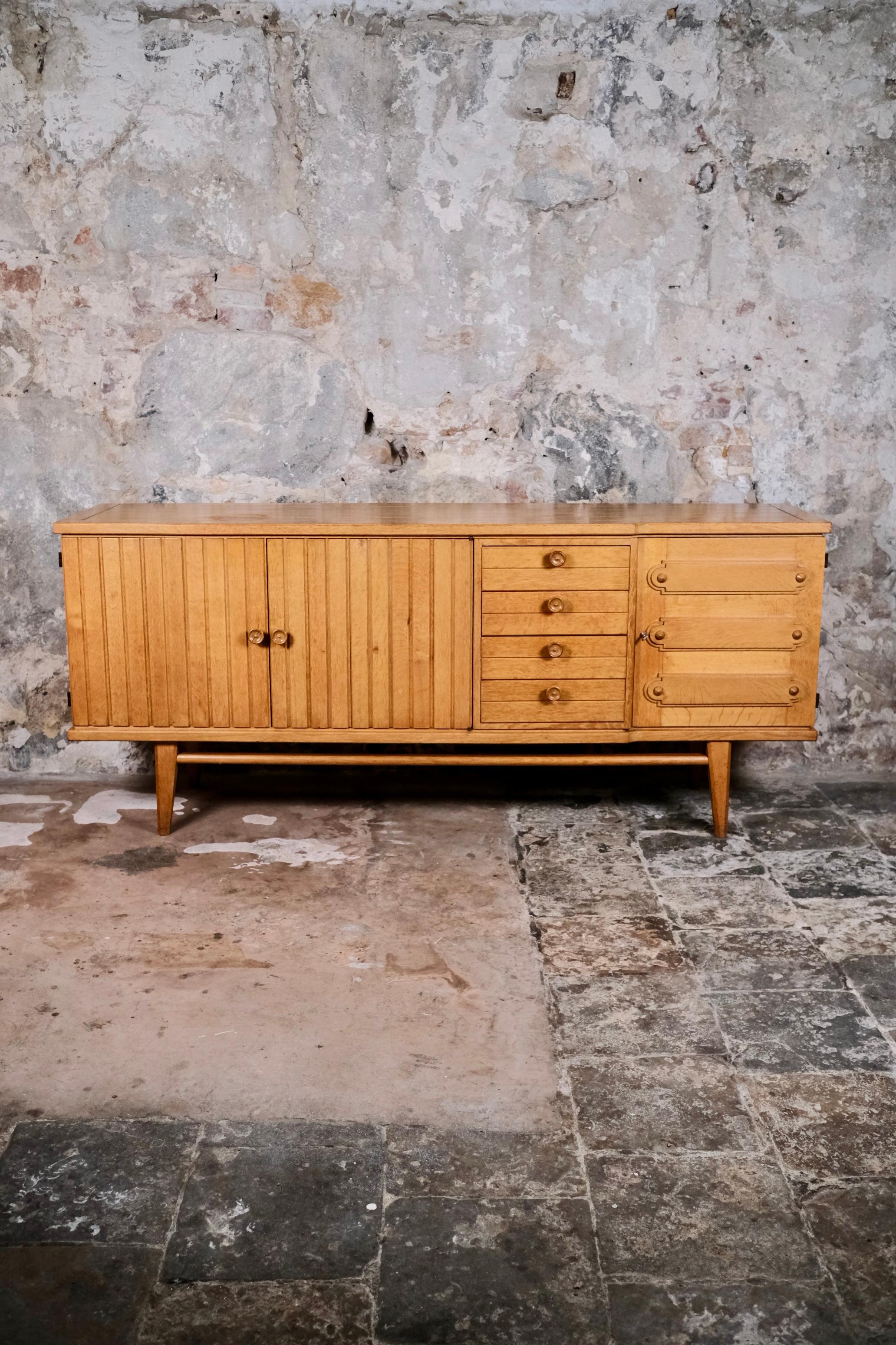 Bellissima credenza in Oak e ottone, nello stile di Guillerme et Chambron, Francia, anni '60.
Elegante e robusta, questa credenza incarna l'eccellenza dell'artigianato francese degli anni Sessanta. 
Realizzato in rovere massiccio, si distingue per