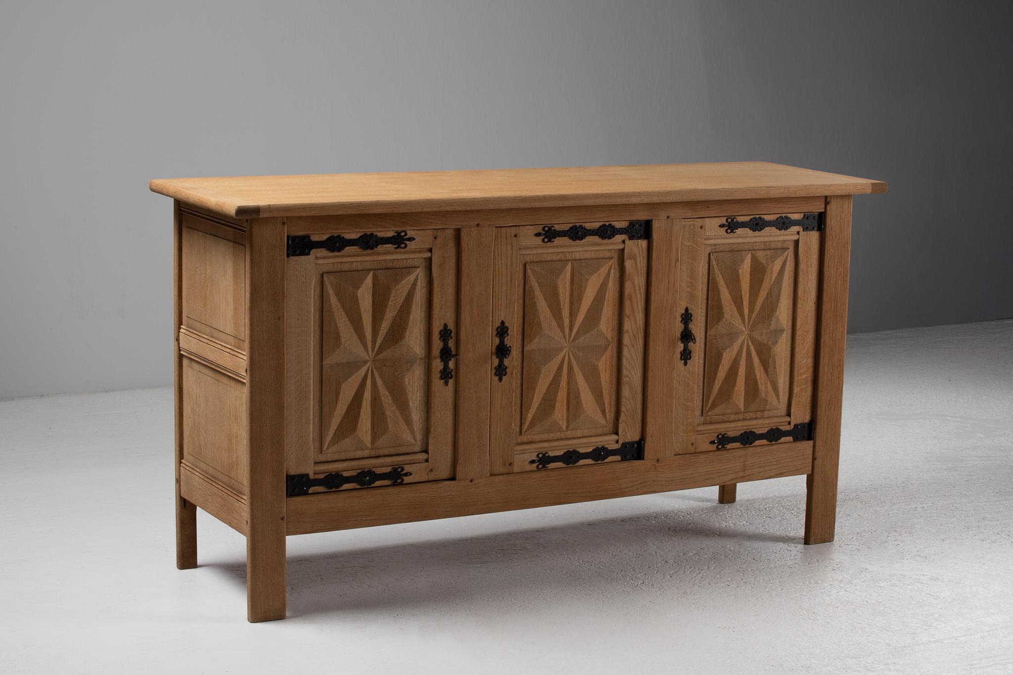 Defined by its luminous geometry and quiet poise, this French oak sideboard is a refined expression of rural craftsmanship, distilled into modern simplicity. Three front panels are adorned with deeply carved starburst motifs, radiating from the