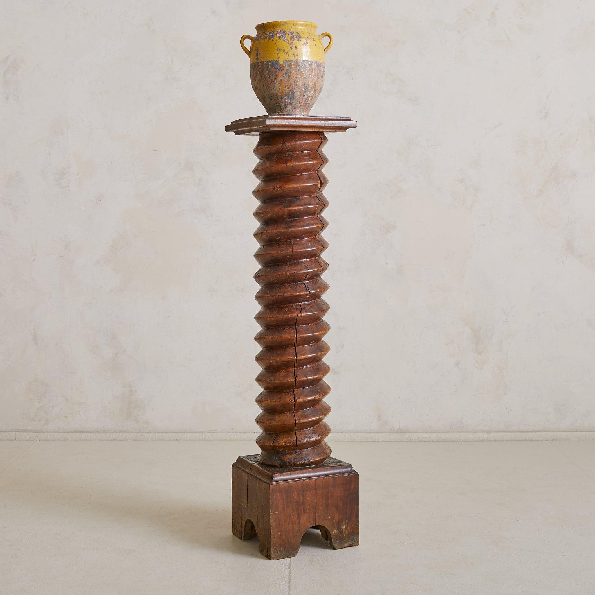 Un piédestal en bois français des années 1940, rappelant les designs de Charles Dudouyt. Cette pièce sculpturale présente une colonne hélicoïdale, sculptée à la main dans du chêne richement patiné et ancrée dans une base robuste. Le plateau en