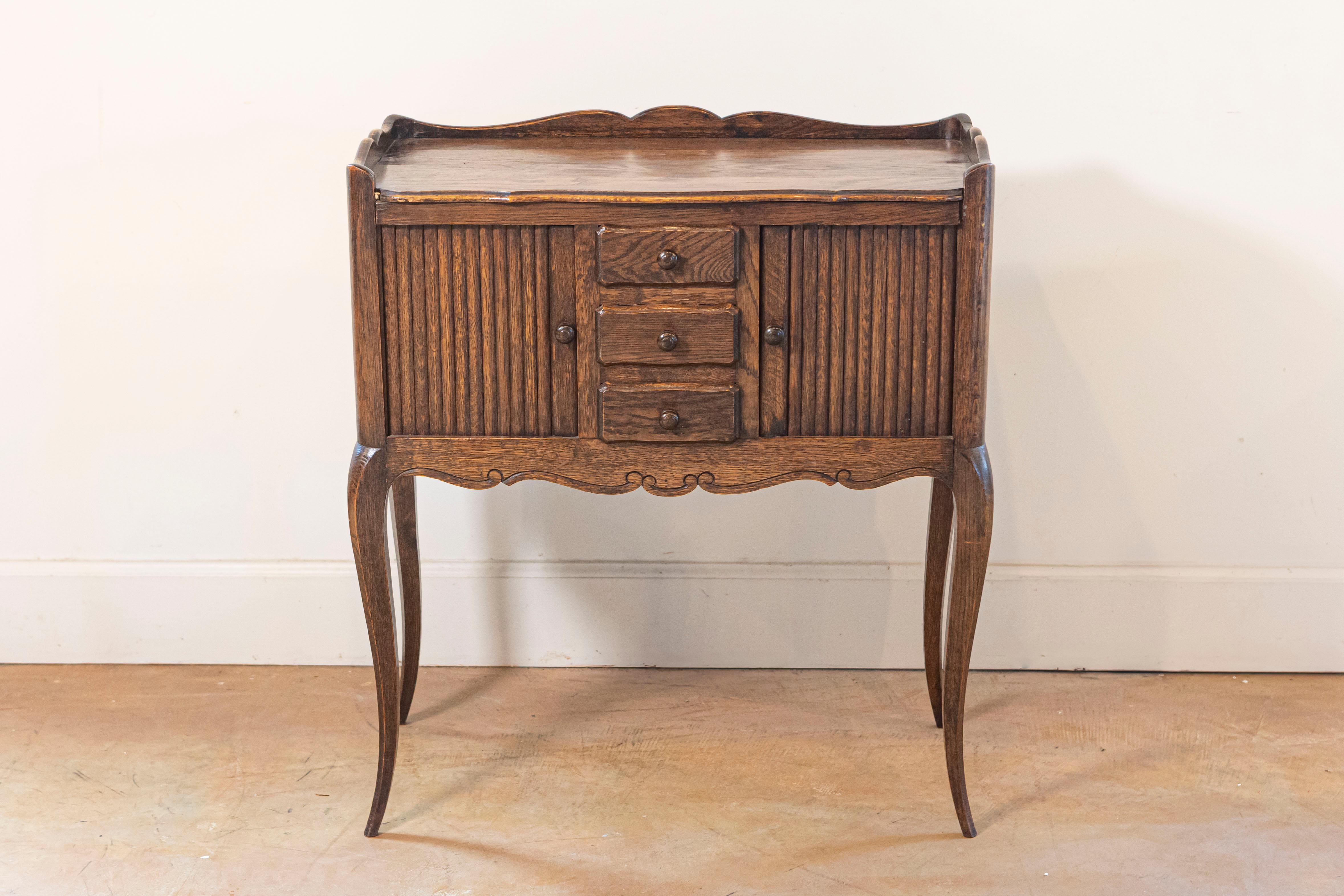 Table de chevet en chêne français avec deux armoires à portes coulissantes et trois tiroirs, de la fin du 19e siècle. Cette table de chevet française présente un plateau rectangulaire entouré d'une galerie en bois aux trois quarts, surmontant deux