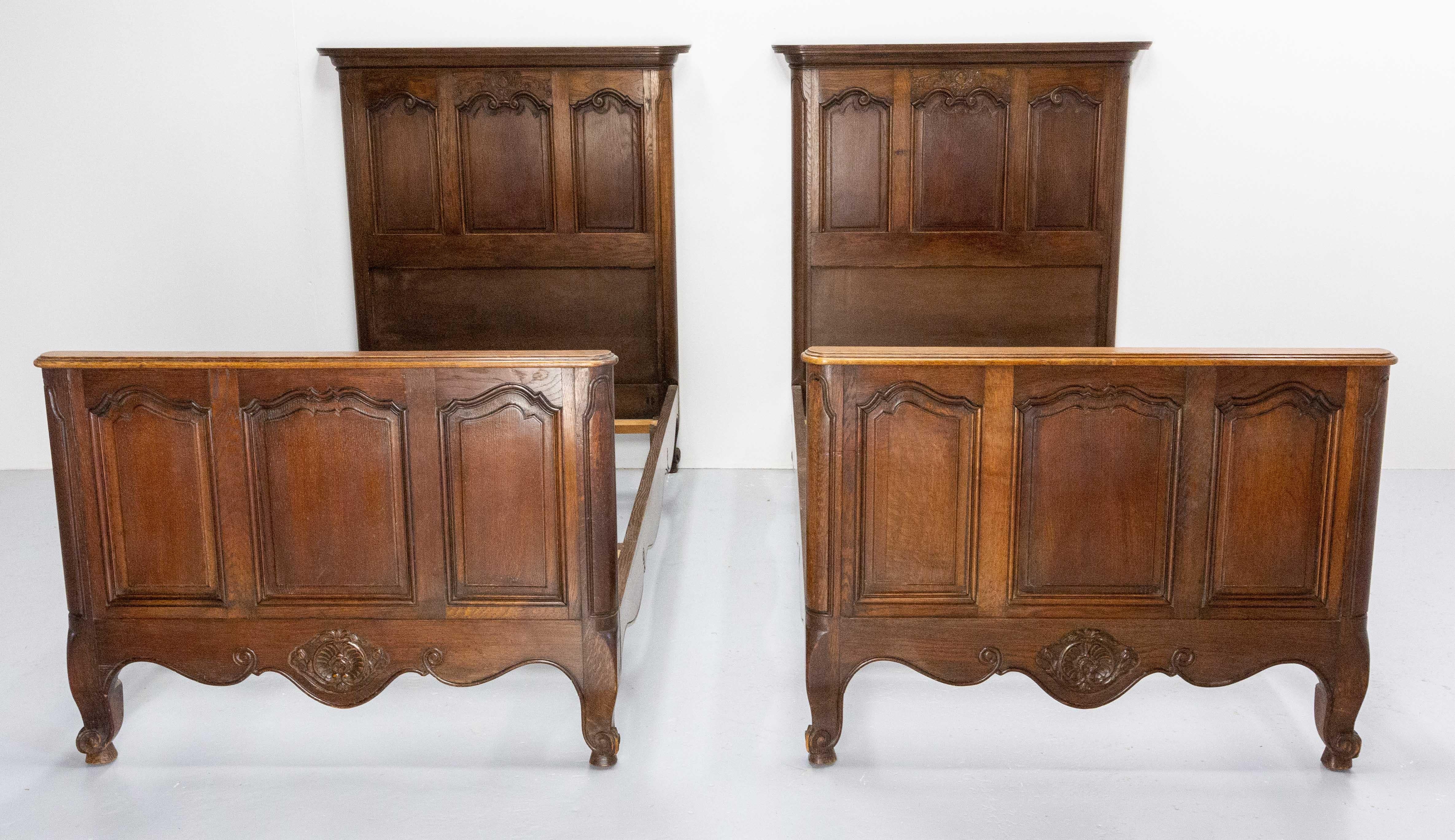 French twin beds in the Louis XV style : carved vegetable shells and decorations on the heads and the foots of the beds
Massive oak, made in the 20th mid-century
Dimension for the bedding: 
74.80 x 36.22 in. (190 x 92 cm)
Good vintage condition