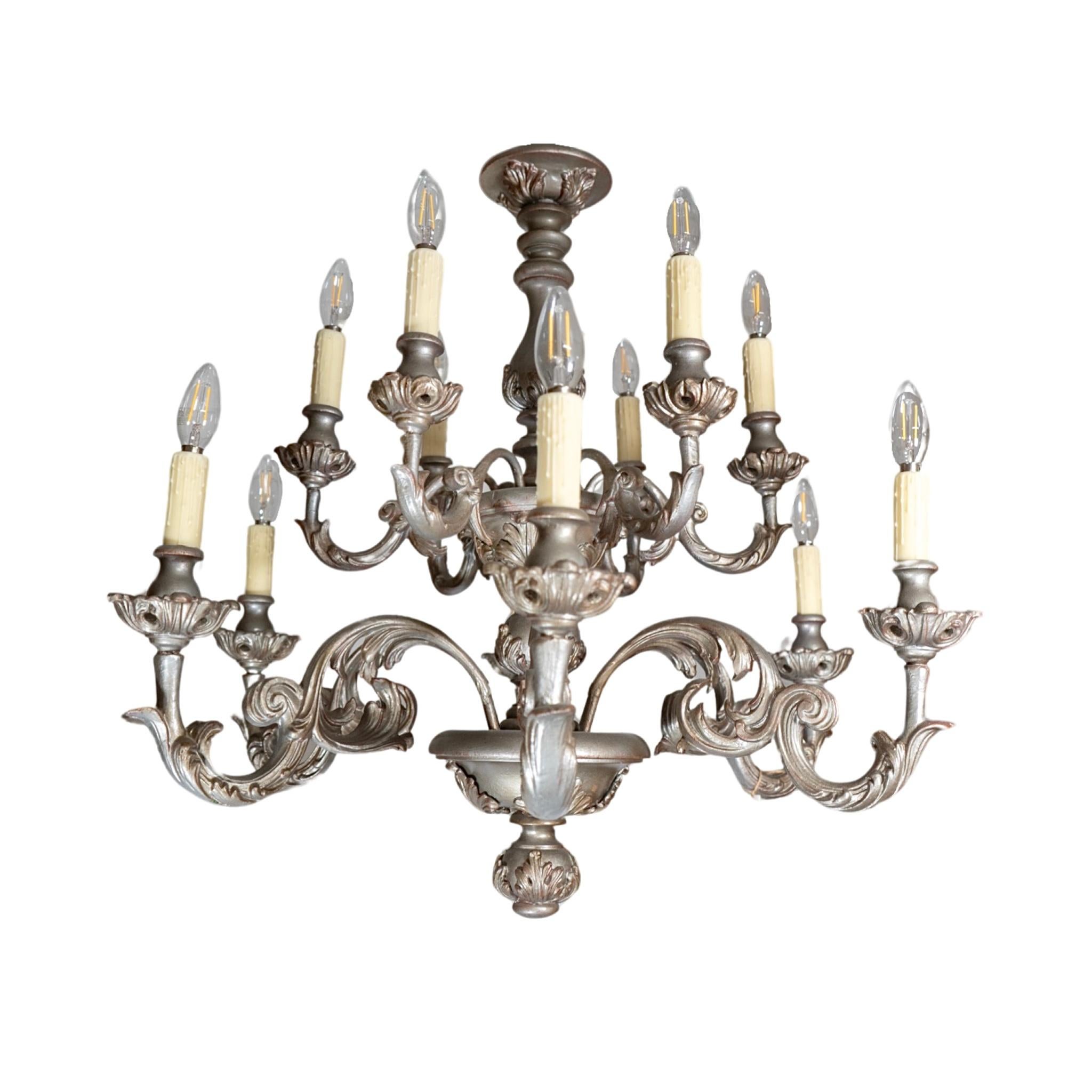 Realizzato in legno di Oak francese negli anni '70, questo lampadario vanta un'eleganza senza tempo grazie alla sua finitura a foglia d'argento. Cablato con competenza e pronto per l'installazione, dona un tocco di lusso a qualsiasi spazio. Eleva il