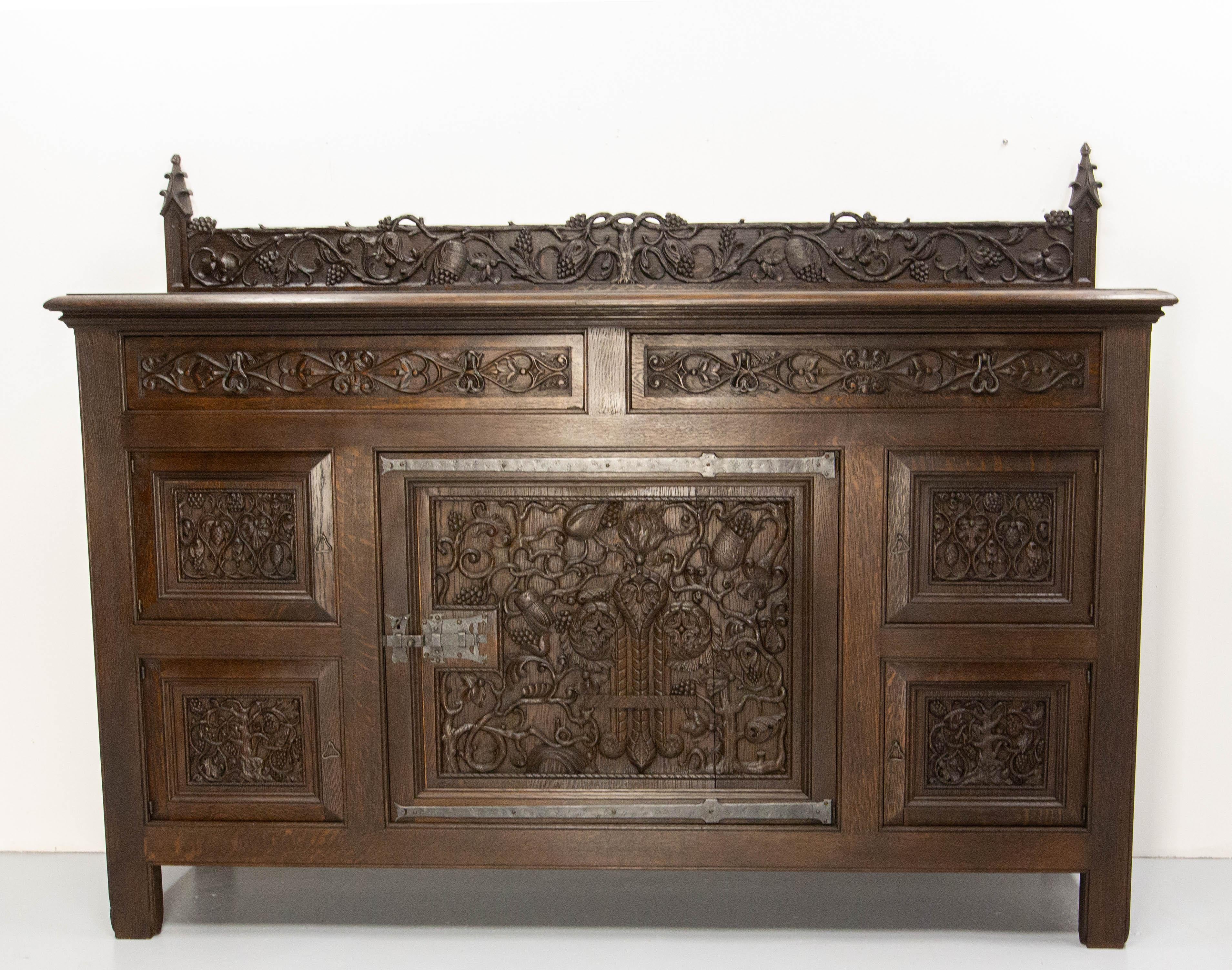 French oak sideboard buffet in the neogothic style.
Adolphe de Beyne was a cabinetmaker from the North of France. 
After the Word War I he specialized in high-end furniture, of which this sideboard is one of the remarkable examples. 
On this buffet,