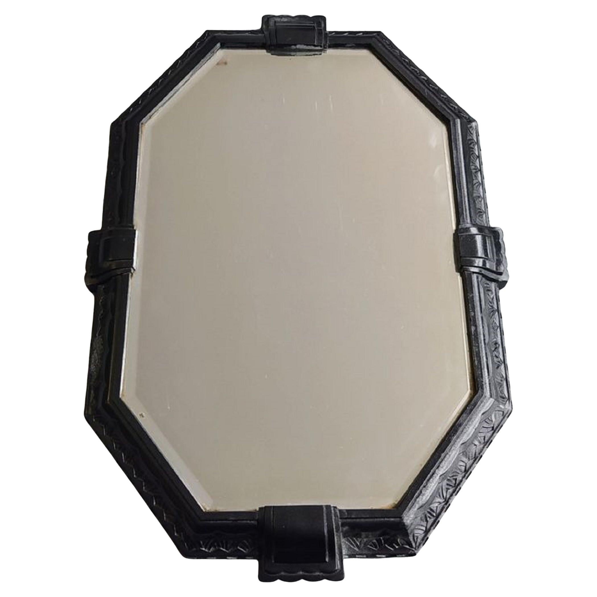 French Octagonal Art Deco Cast Iron Mirror with Fine Stylized Decoration 1930s

The mirror has a frame decorated with stylized leaves and waves.
In addition, four decorative elements, almost like belt buckles, are placed on the outer edges.
The edge