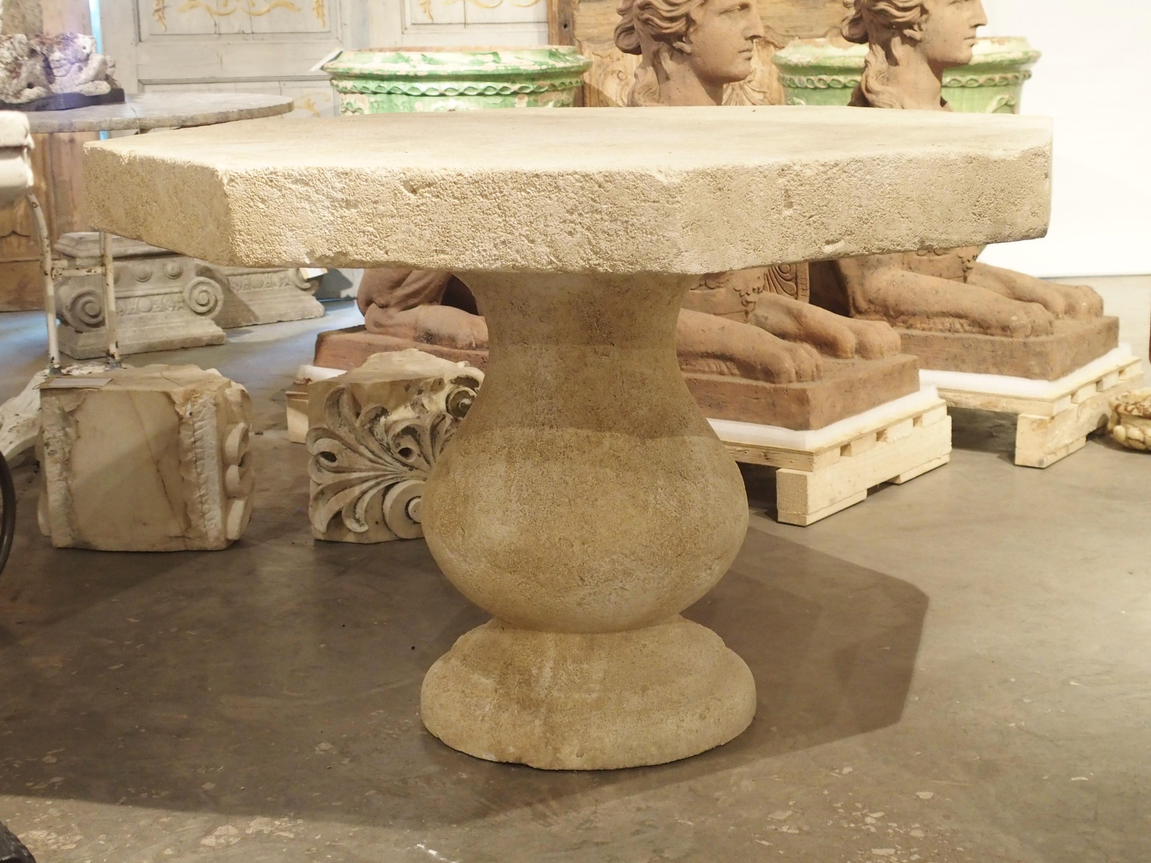 This versatile, hand carved, octagonal stone table from France can be used outdoors as well as inside. A four inch thick carved top sits on a large, single baluster leg. It is made of French estaillade limestone, which has been used for centuries in