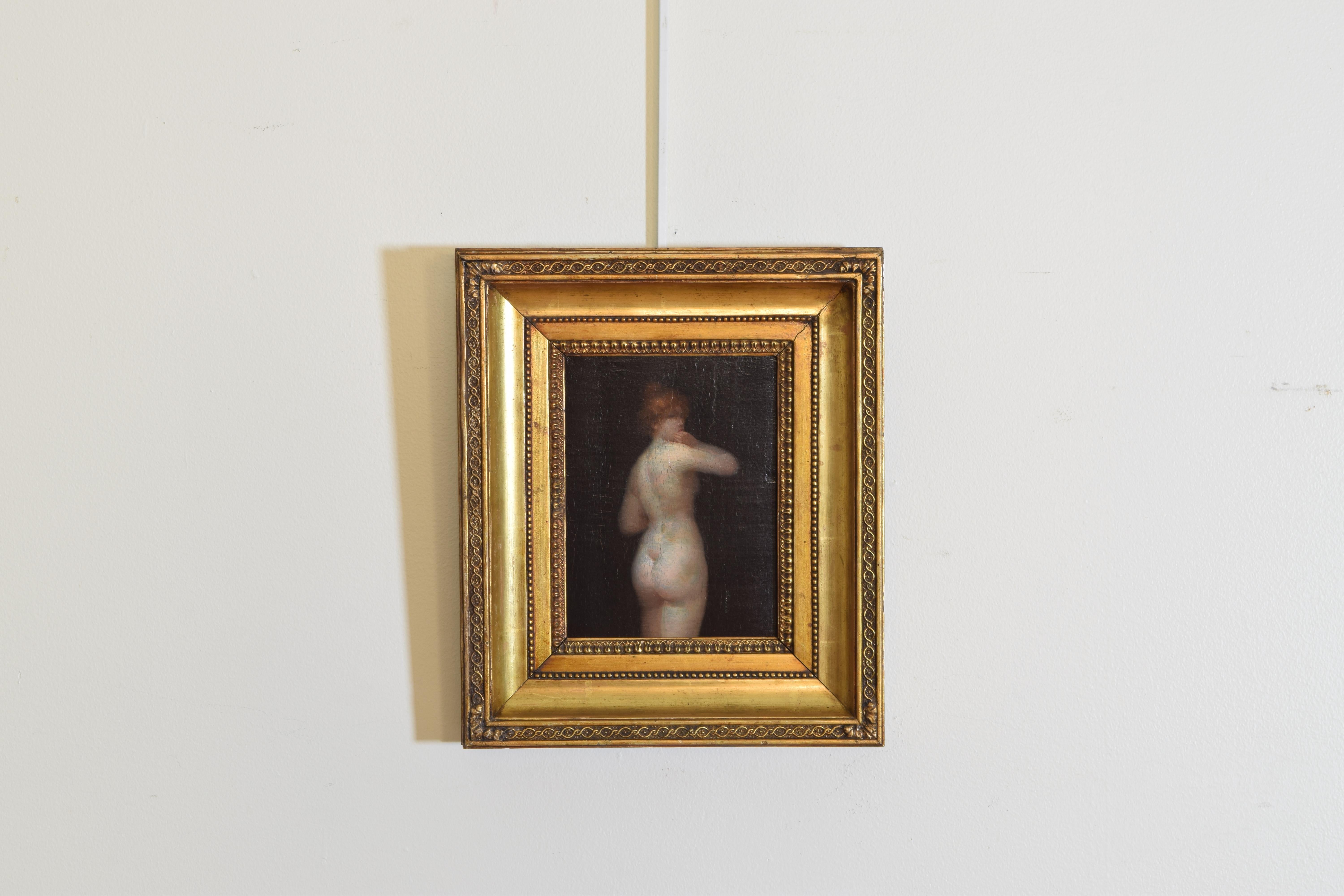 A French portrait from the Beaux Arts period of a female nude with her red hair up in a bun backlit and standing in front of a black screen her hand posed at her mouth, in a period giltwood and gilt gesso frame. Late 19th century-early third quarter