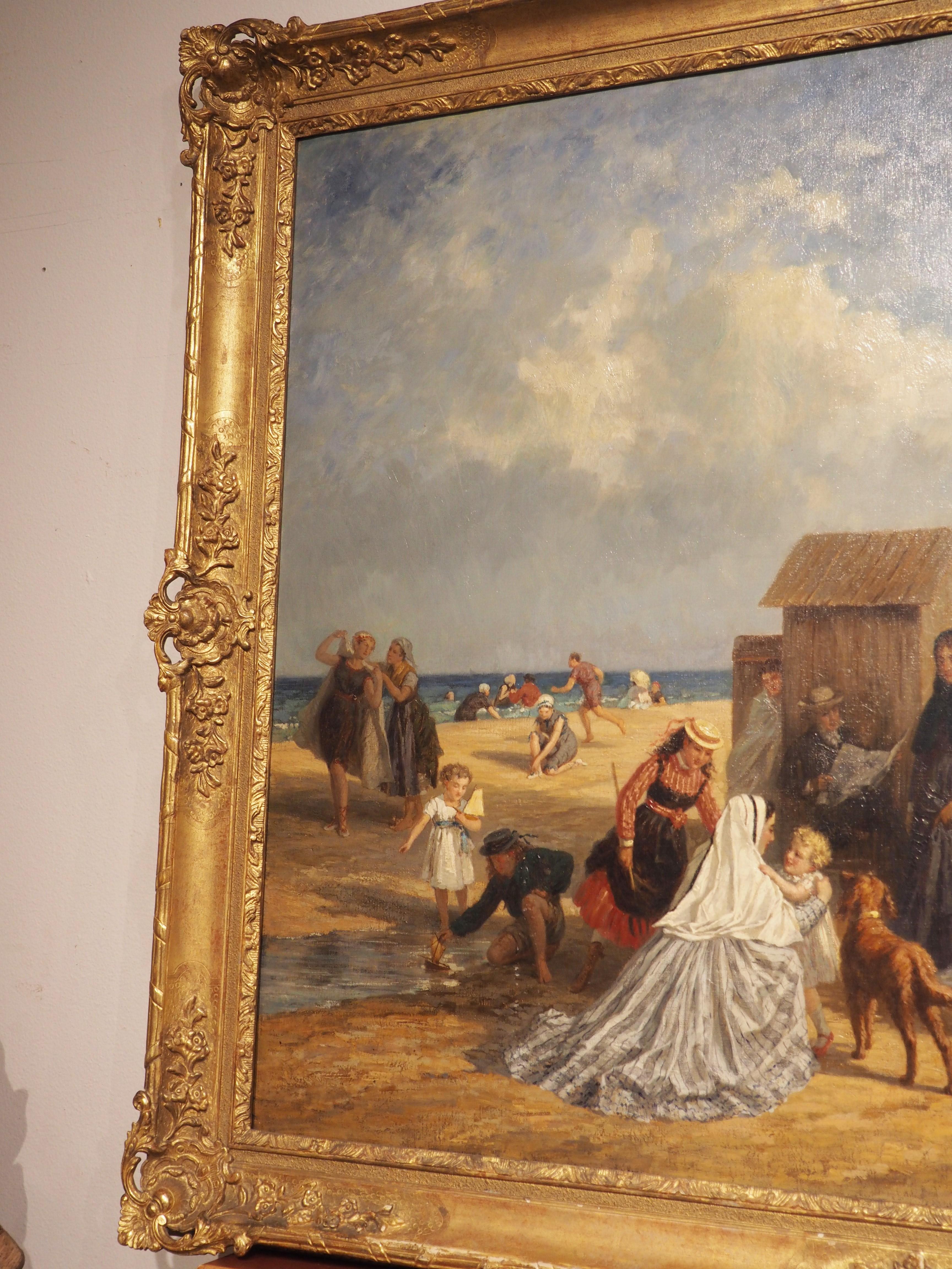 A fantastic depiction of a day at the beach at Trouville in 19th century France, this grand oil on canvas painting by Paul-Emile Morlon is is surrounded by a giltwood frame adorned with carvings of floral margents, Rococo-style foliage, and bundled