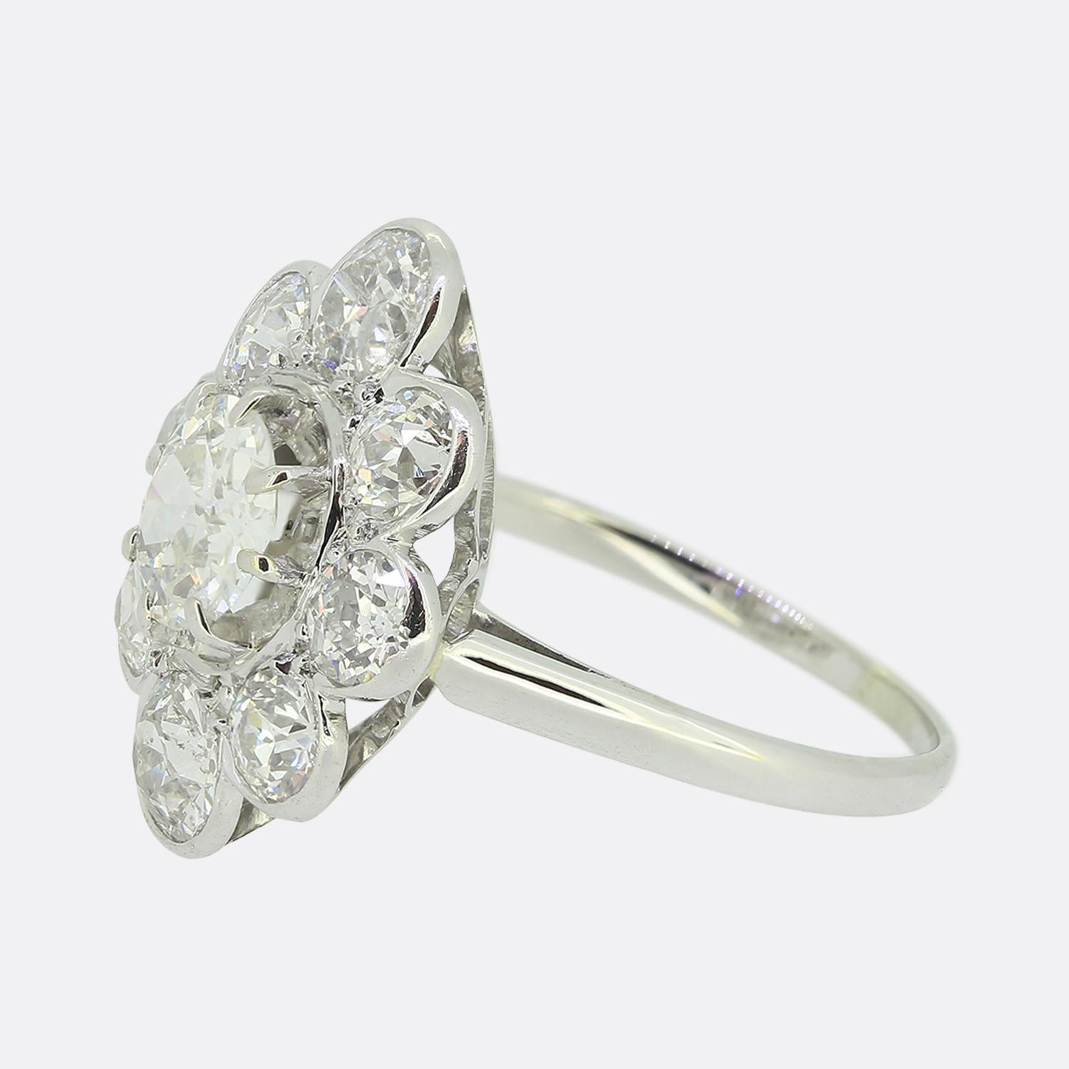 Here we have a fabulous cluster ring crafted in France and featuring a scintillating ensemble of diamonds. At the centre of this vintage piece we find a single round faceted old European cut diamond which sits slightly risen in an 8 clawed setting.