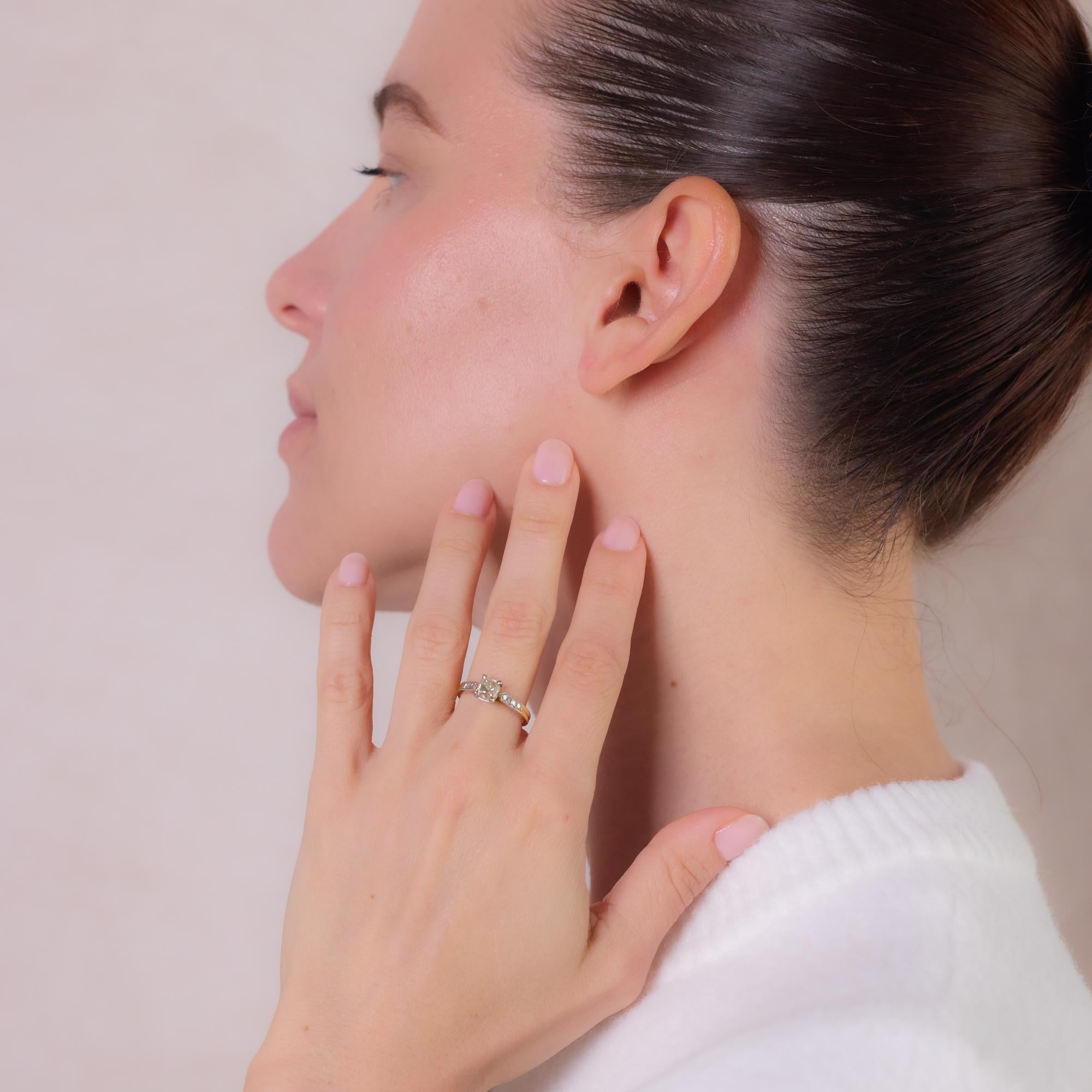 Cette bague de fiançailles française en or jaune 18k et platine présente un superbe diamant taille ancienne d'environ 1 carat, couleur L, pureté SI2, accentué par huit diamants taille unique d'un total d'environ 0,08 carat, couleur G, pureté VS.