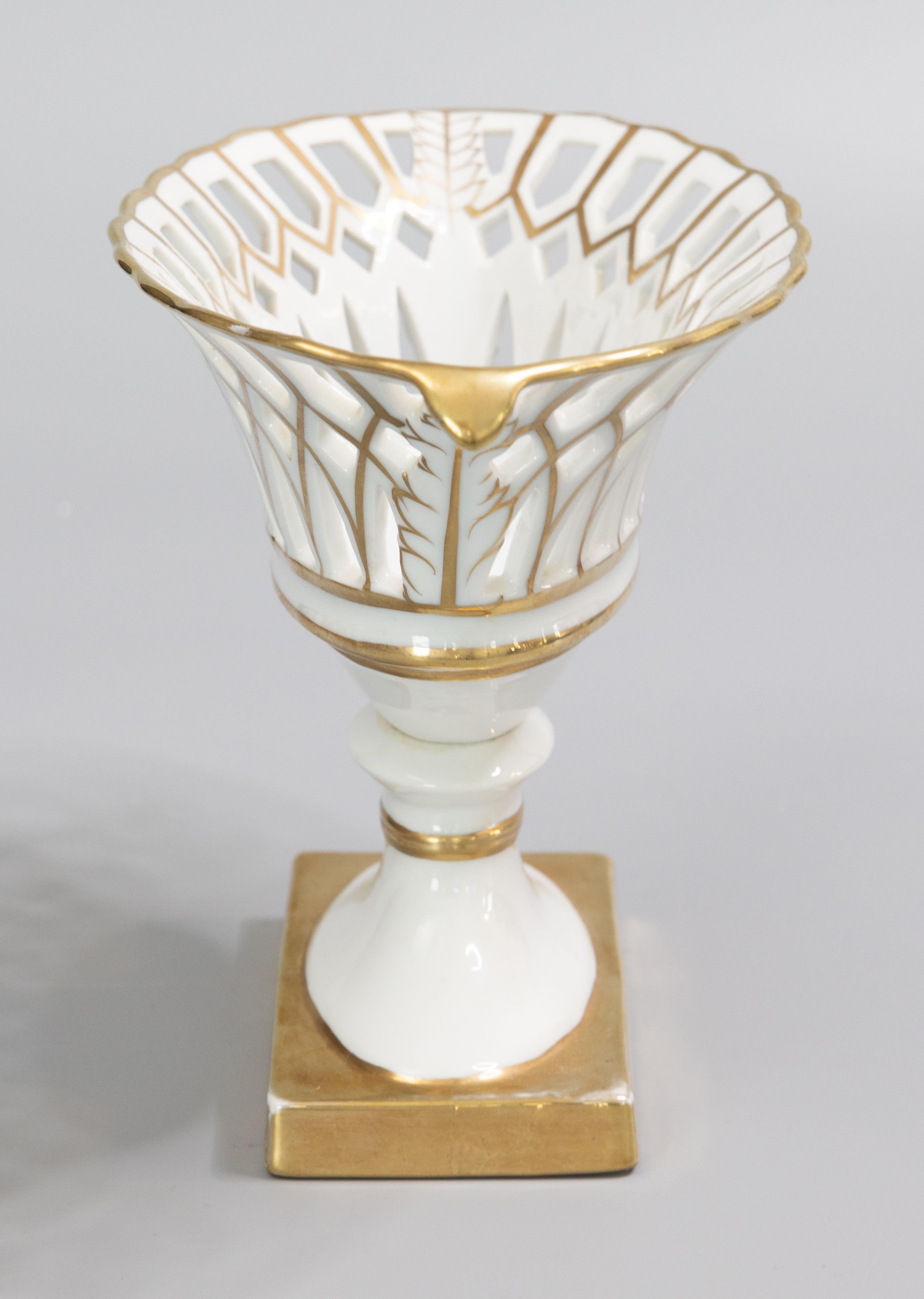 A gorgeous vintage French Old Paris style gilt porcelain basket compote, circa 1950. This elegant pedestal bowl has a lovely reticulated design with stunning gold accents and leaf details. It displays beautifully and would be the perfect accent